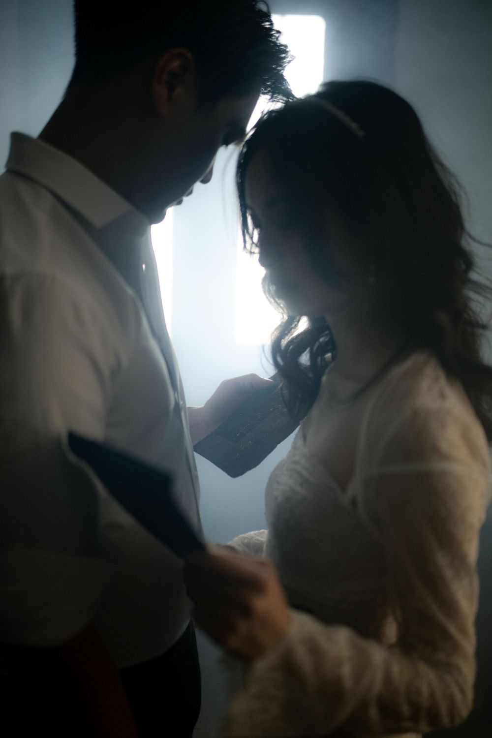 Atmospheric scene of two people in silhouette sharing an intimate moment.