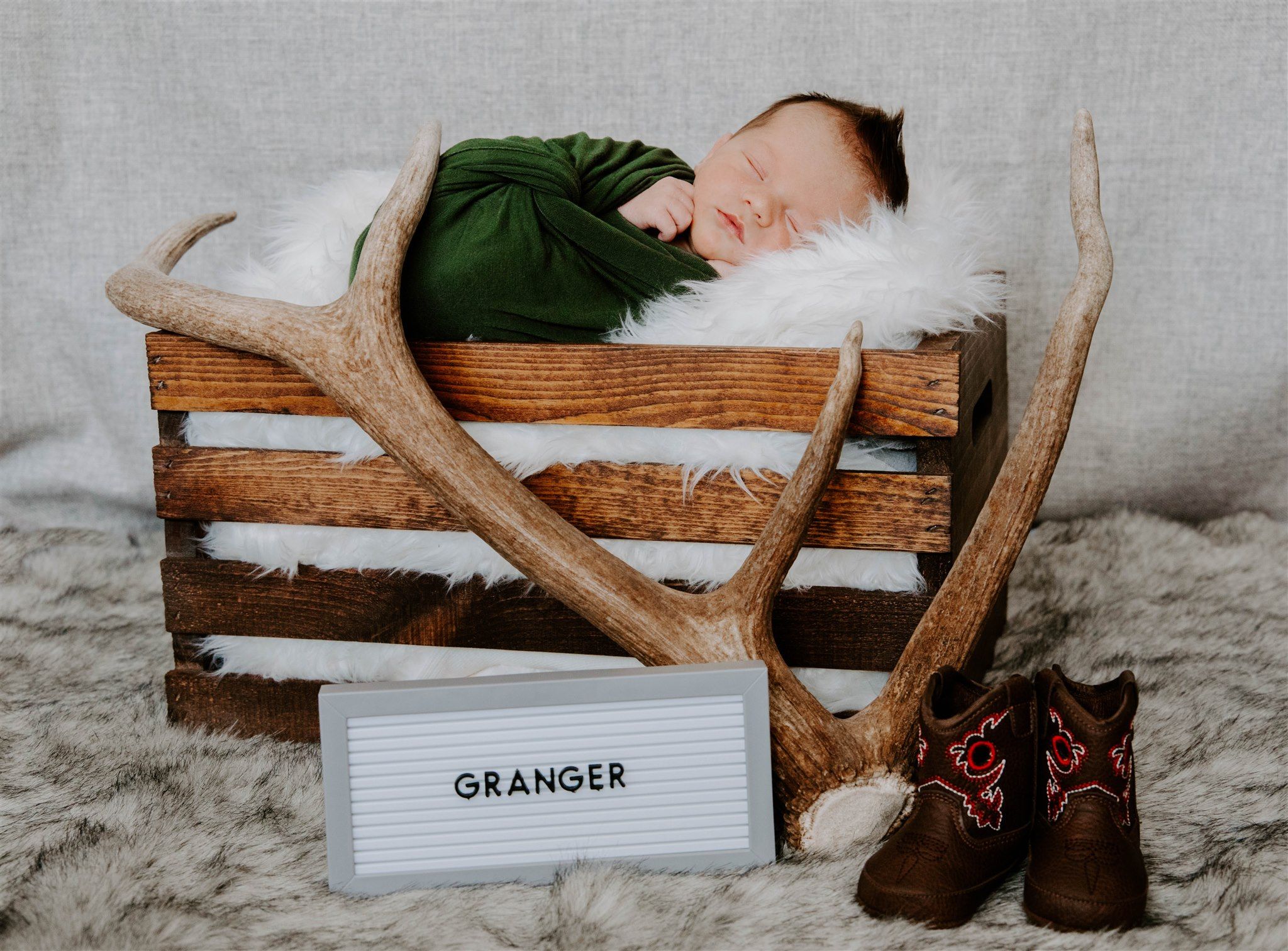 Rustic wooden decor and antlers arranged with text display.