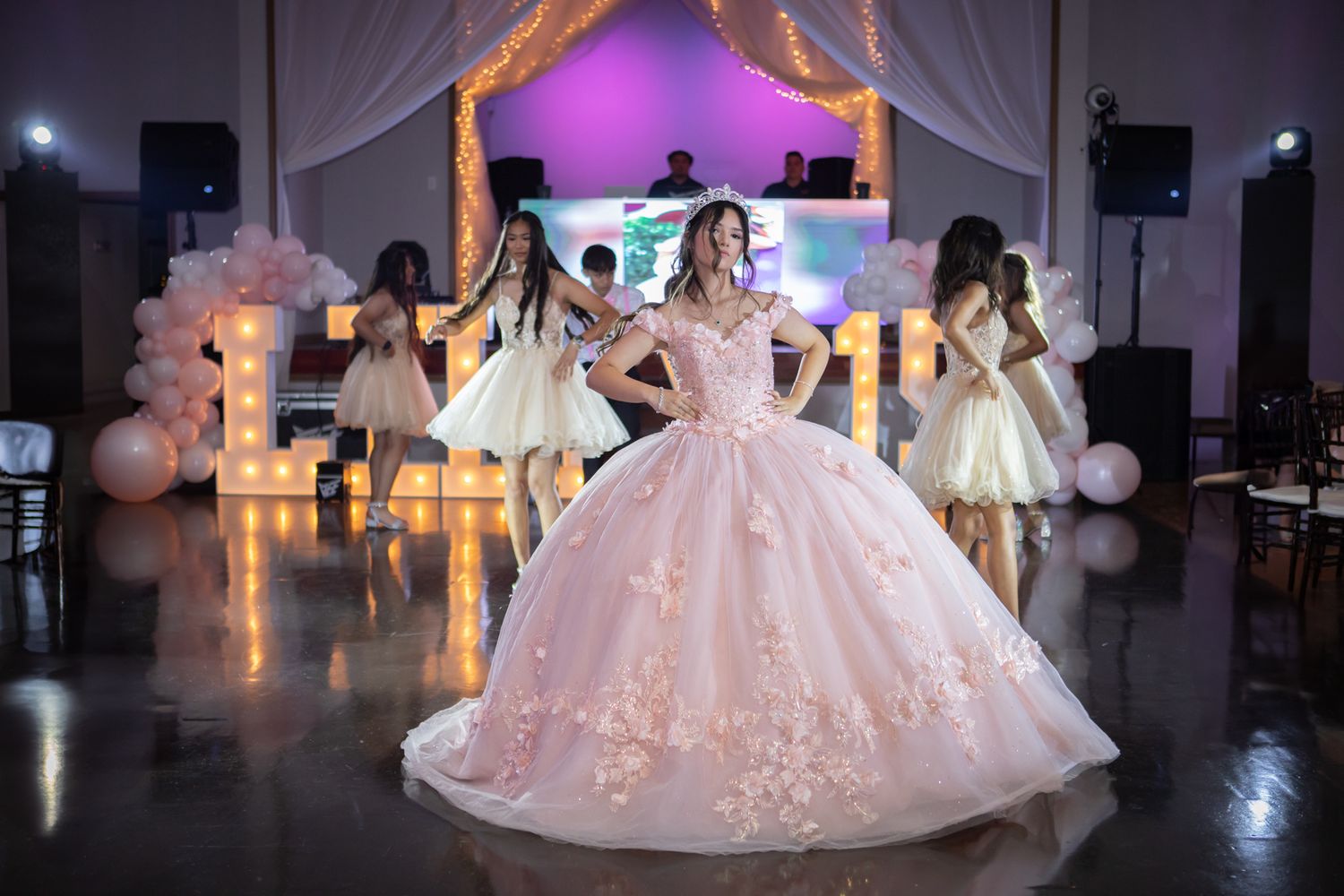 Pink quinceanera with her court in waltz