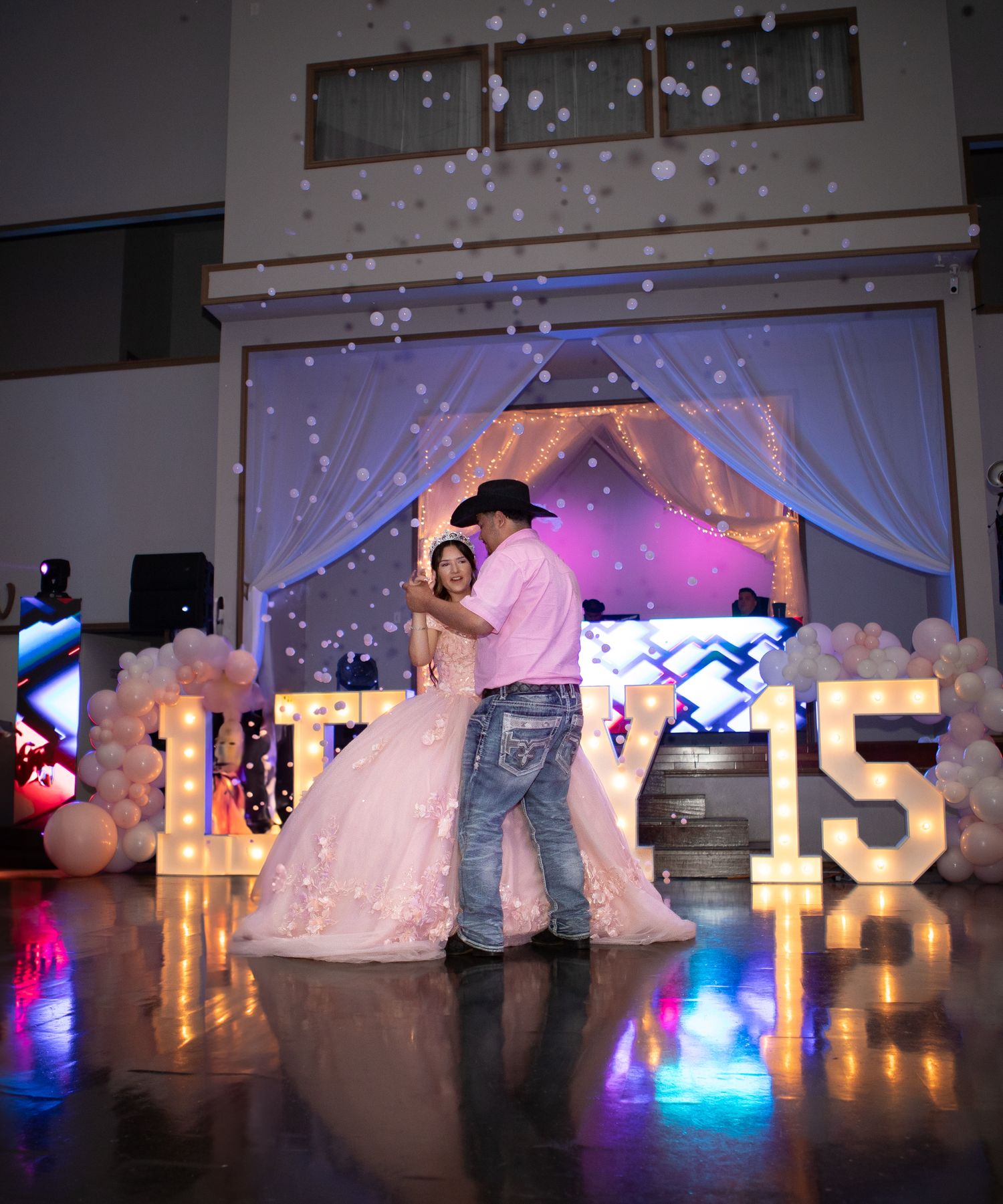 Pink Quinceanera dancing with bubbles around her