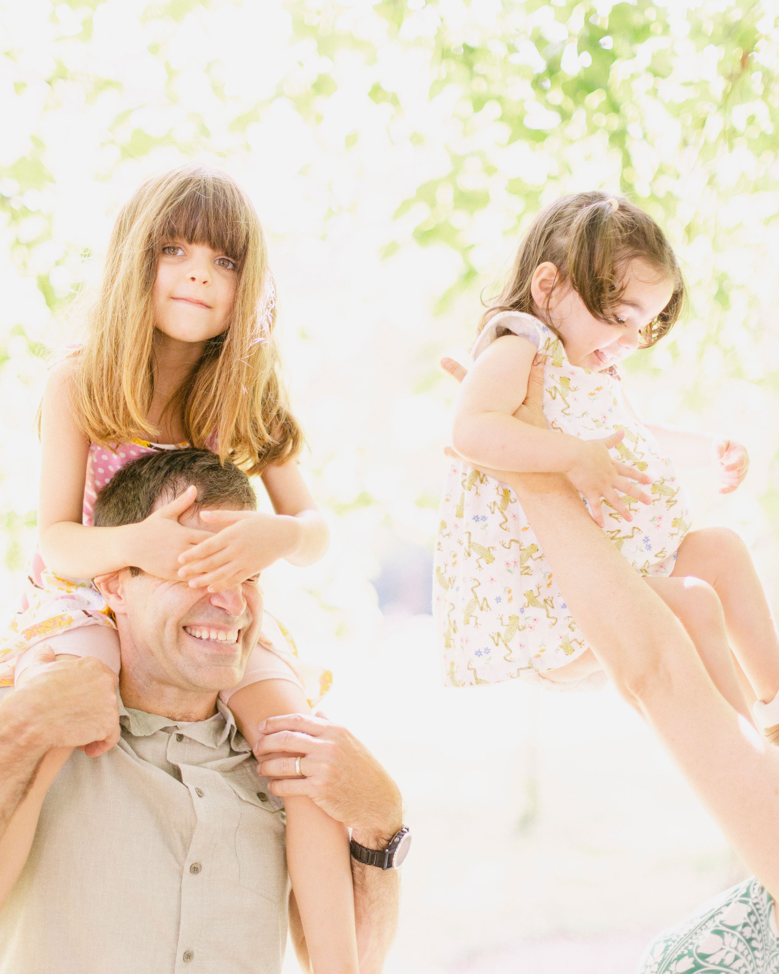 Lighthearted outdoor playtime with shoulder rides and laughter in ethereal lighting.