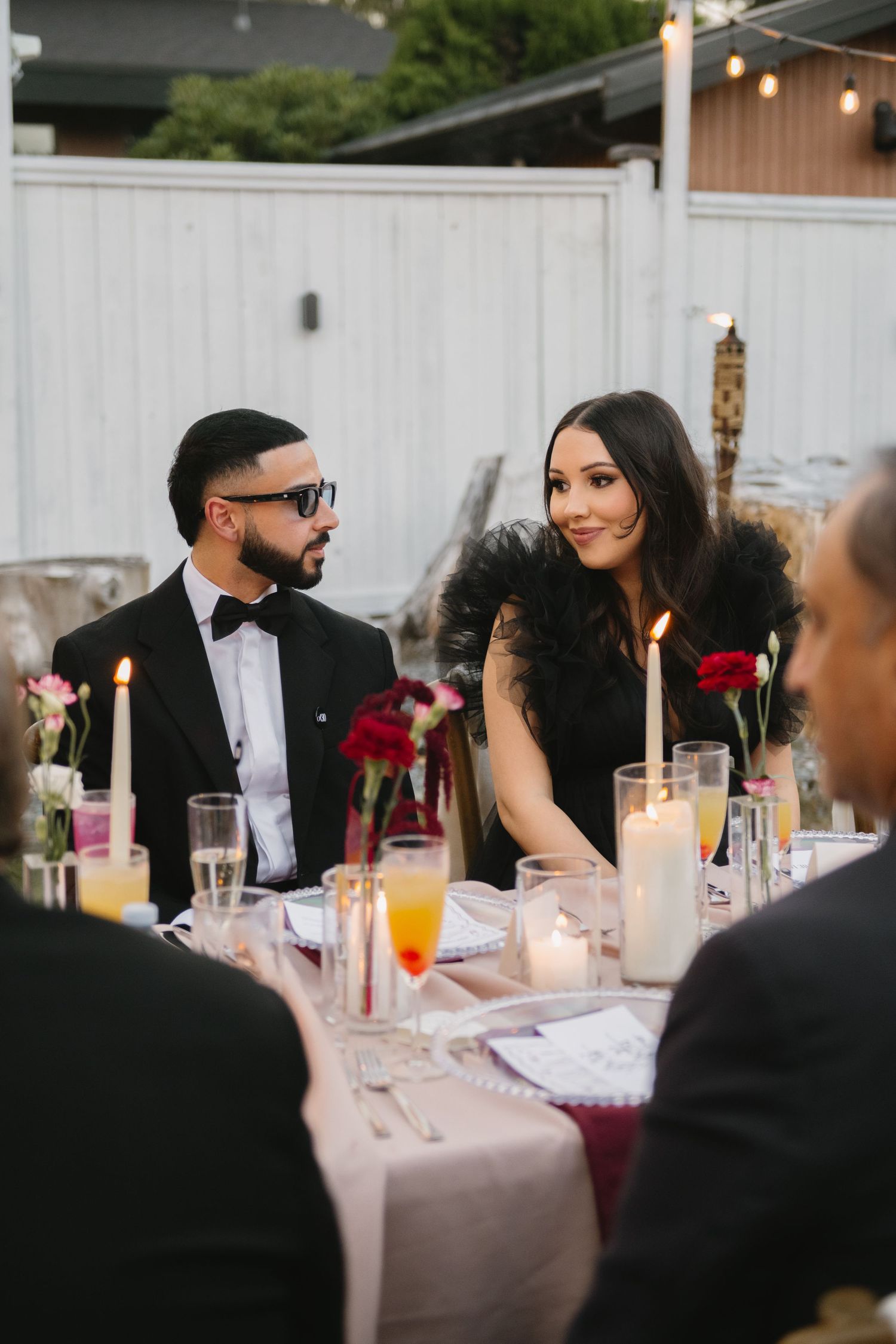 husband and wife looking at each other at a black tie event