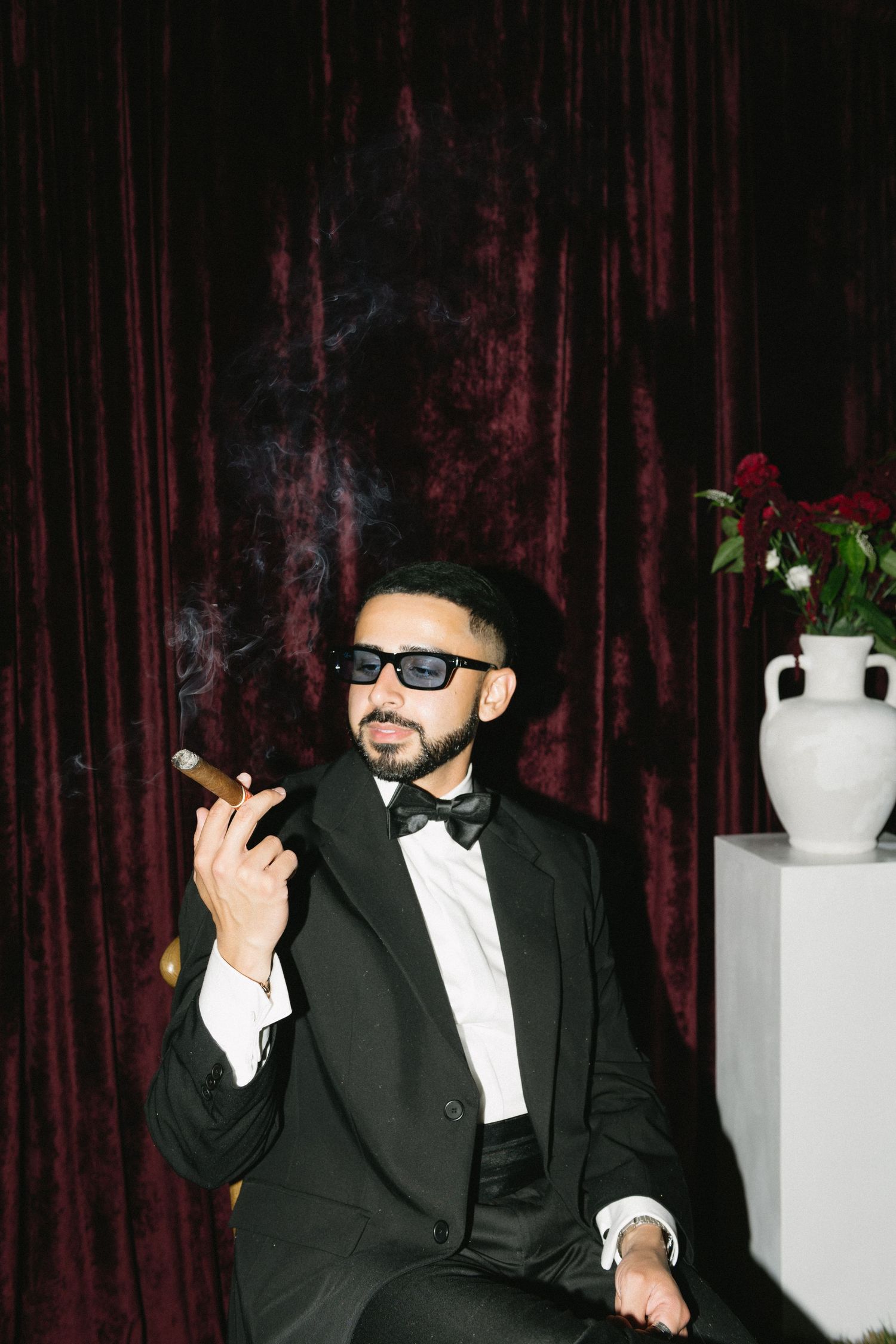 man smoking a cigar in a black suit