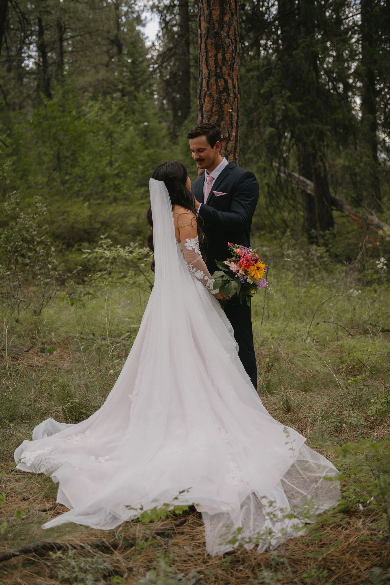 bride and groom kissing in the forest