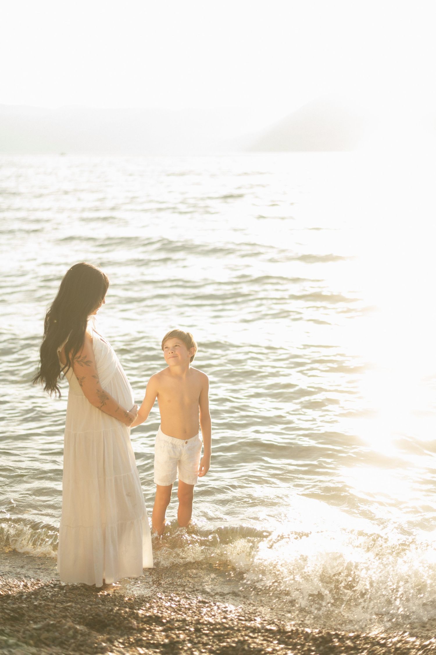pregnant mom holding hands with her young son