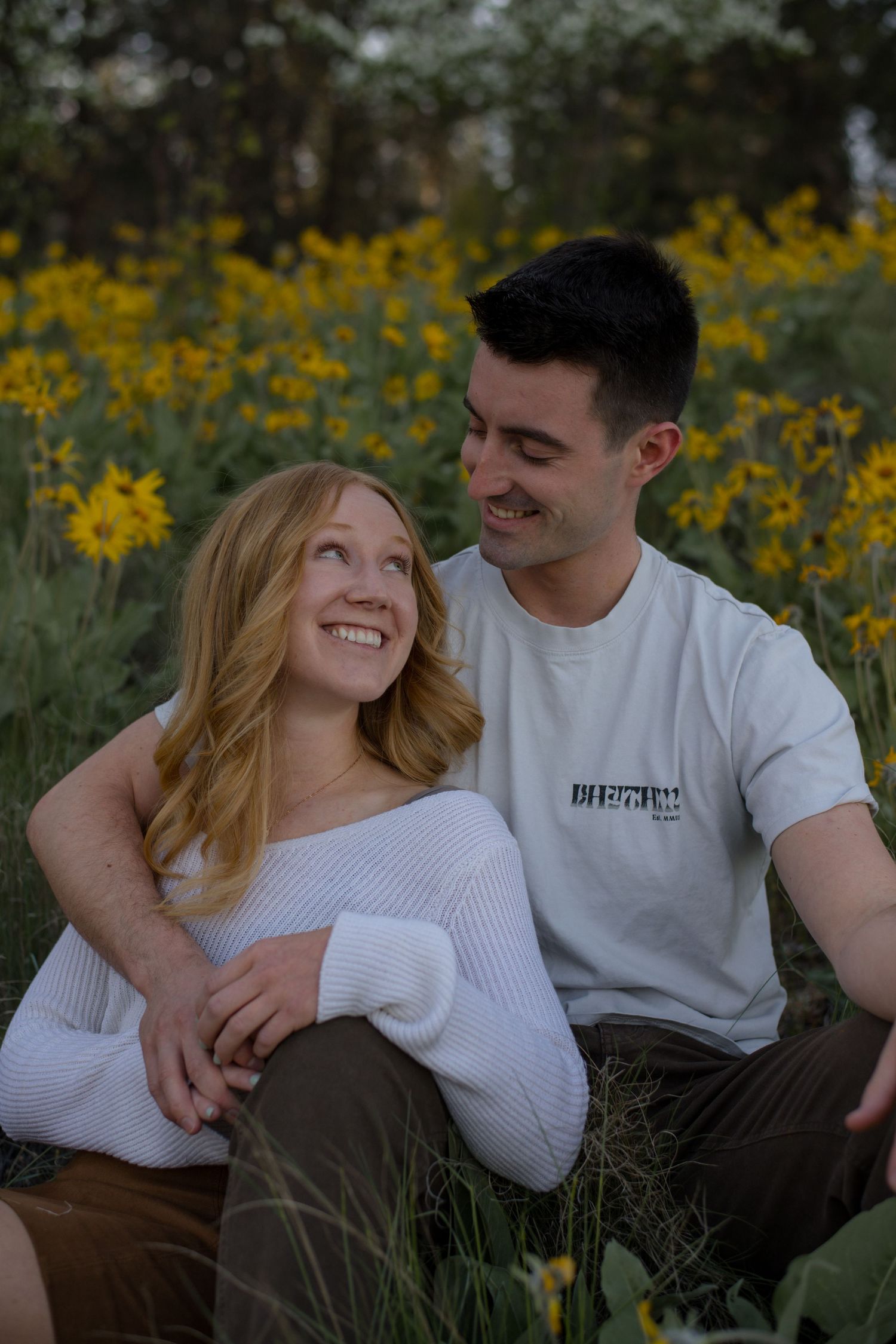 couple hugging in a field of yellow flowers