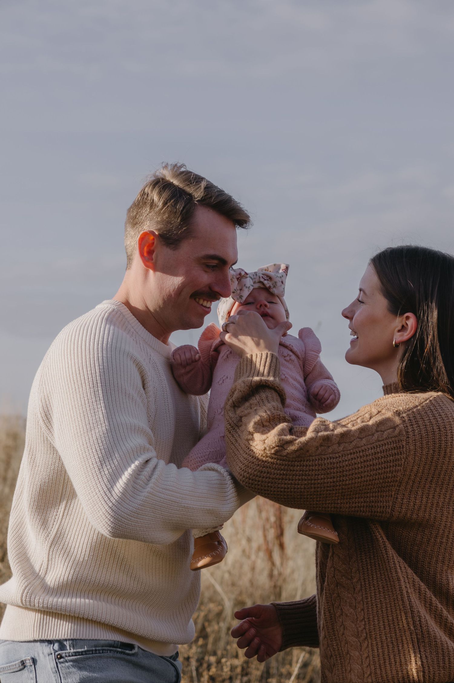 husband and wife with their baby outside