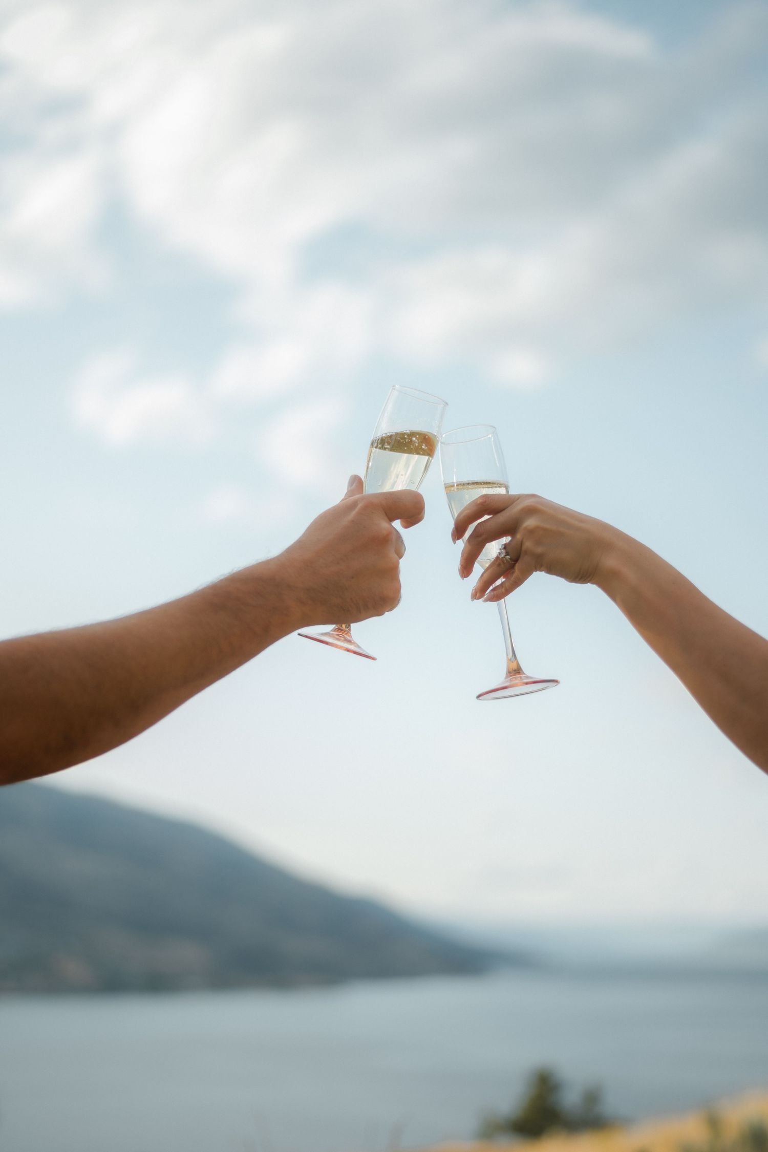 couple holding champagne glasses up towards the sky