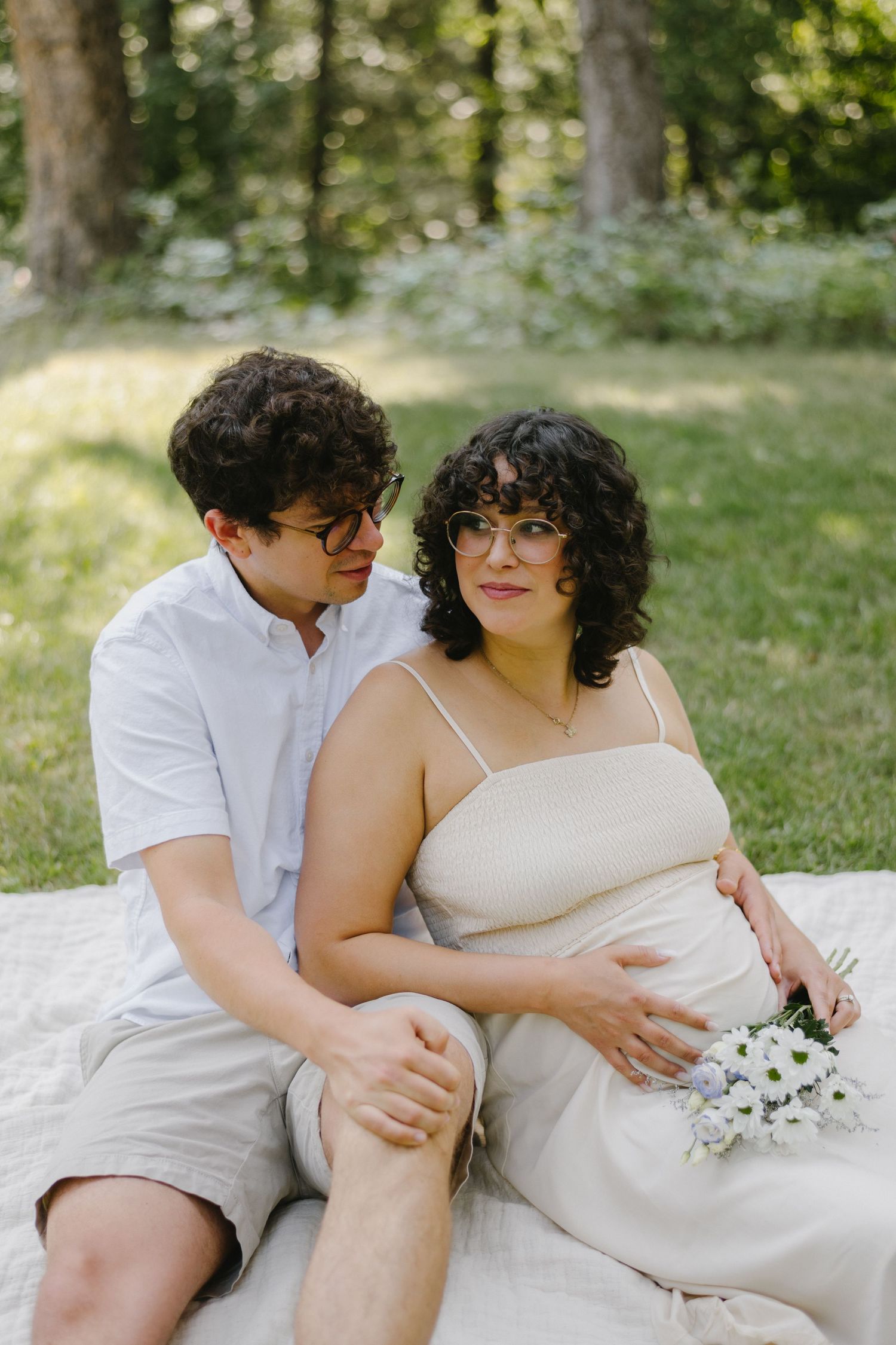 pregnant women and husband sitting in the grass