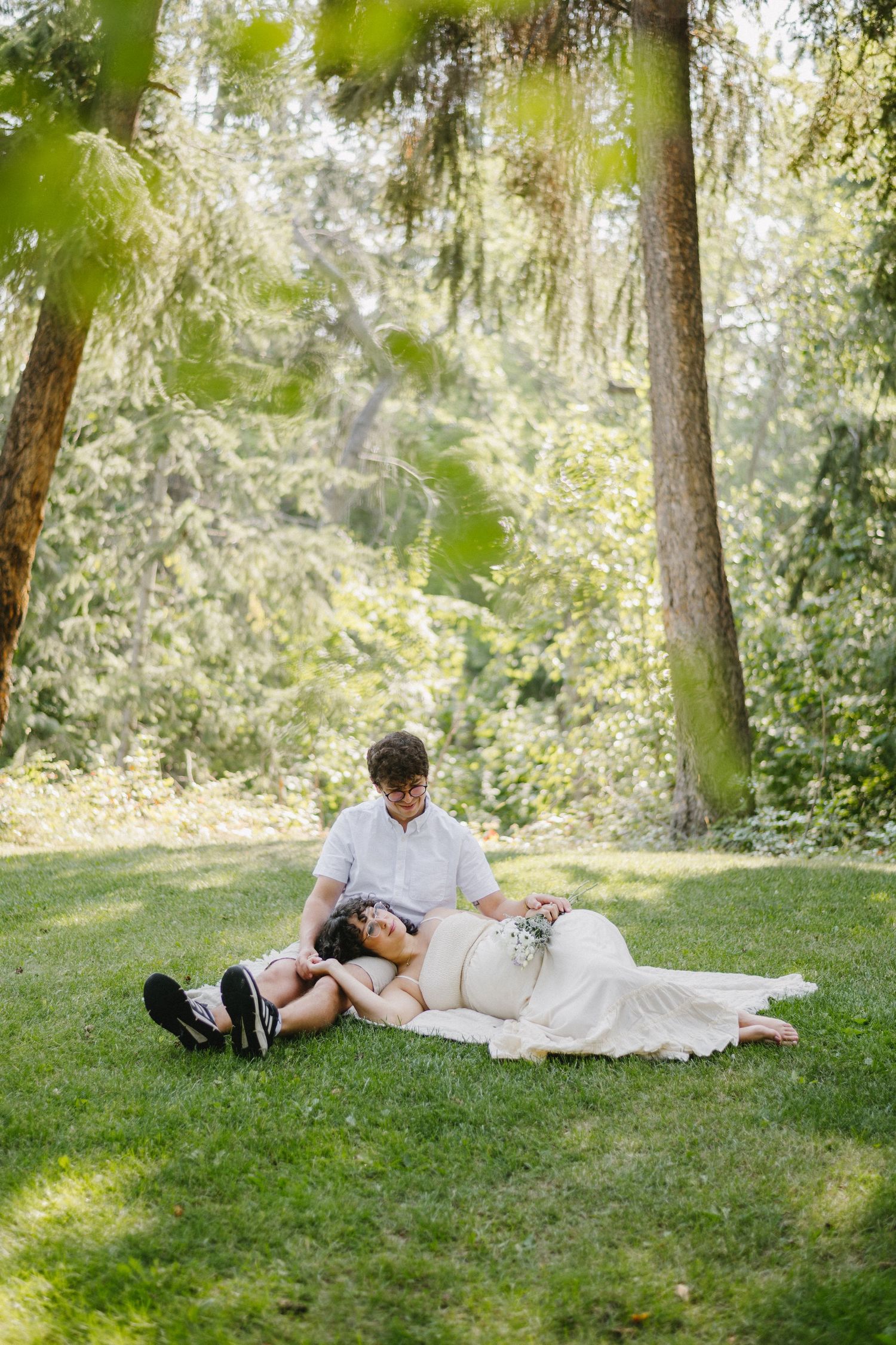 pregnant women and husband laying in the grass
