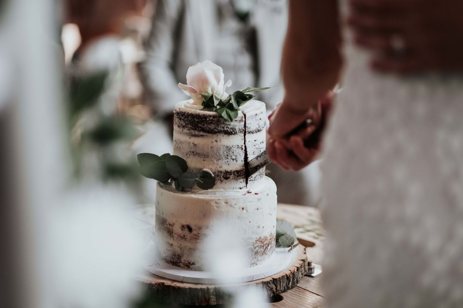 Two tier wedding cake being cut