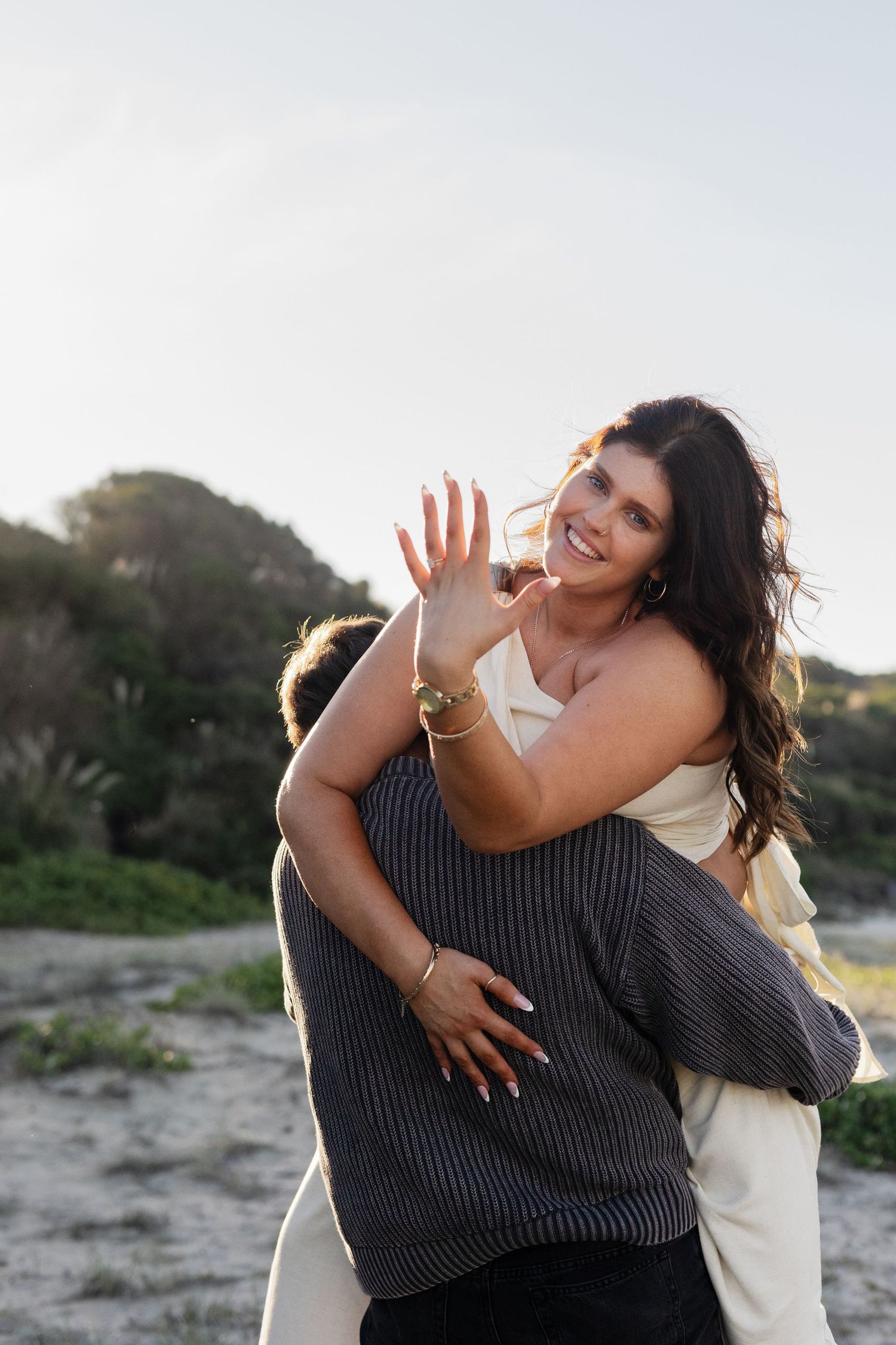An intimate embrace captured at sunset in a desert landscape.