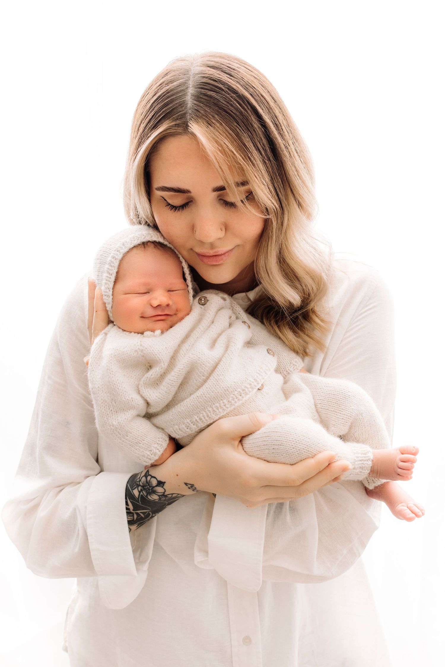 nyfødt mamma med smilende baby i hender
