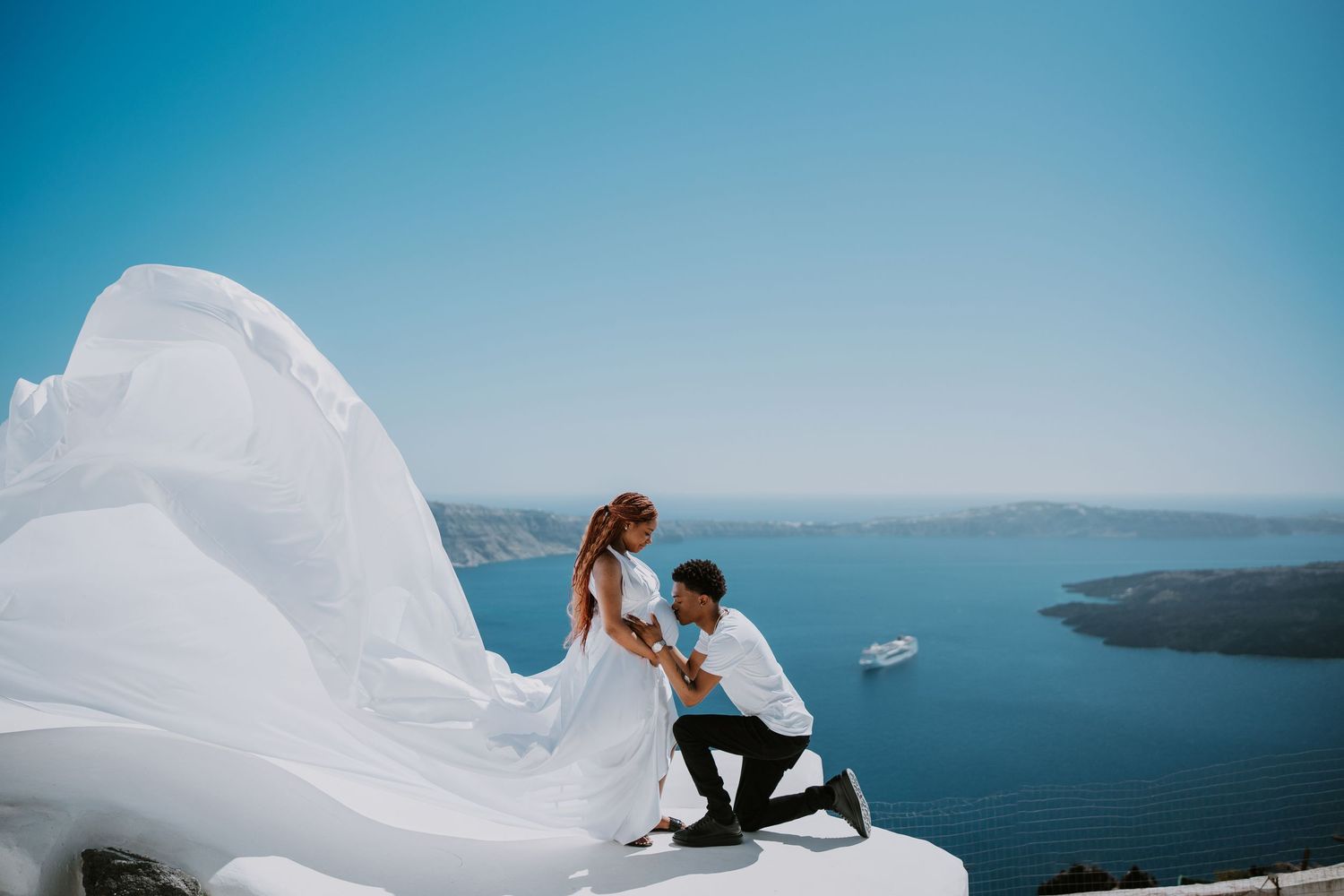 Romantic moment captured on white rooftop overlooking Santorini's blue waters.