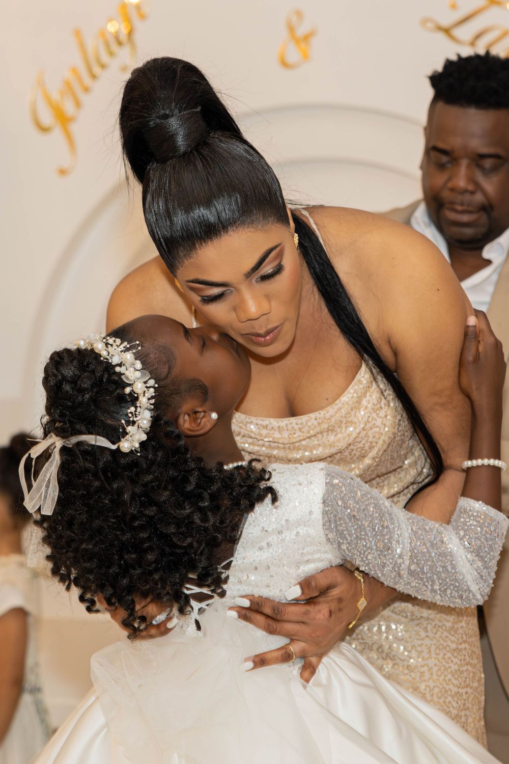 Emotional moment captured between wedding party members in formal attire.