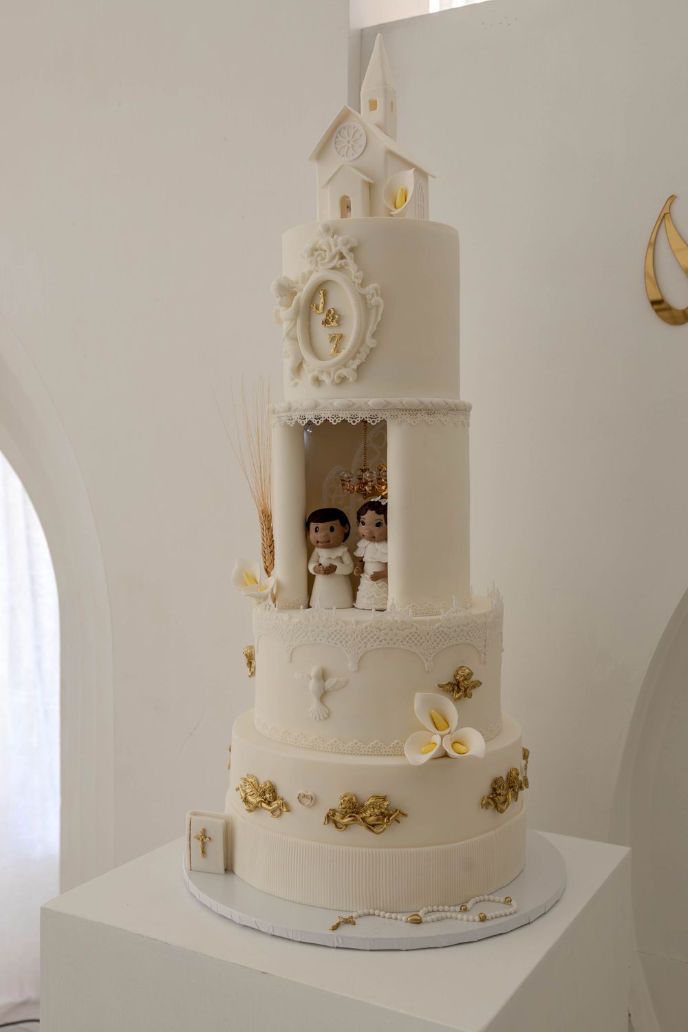 Elegant white wedding cake with intricate details and floral decorations on display.