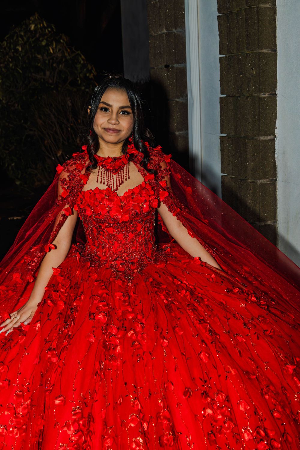 Stunning red ball gown with intricate floral details and a voluminous tulle skirt.