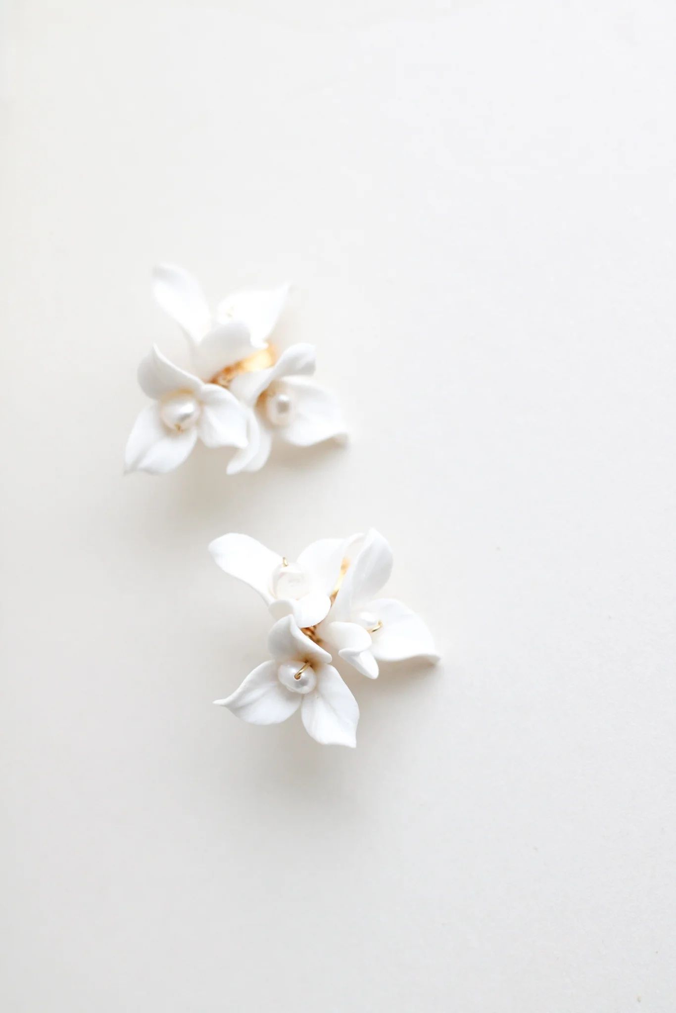 Delicate white porcelain flower decorations on light background.