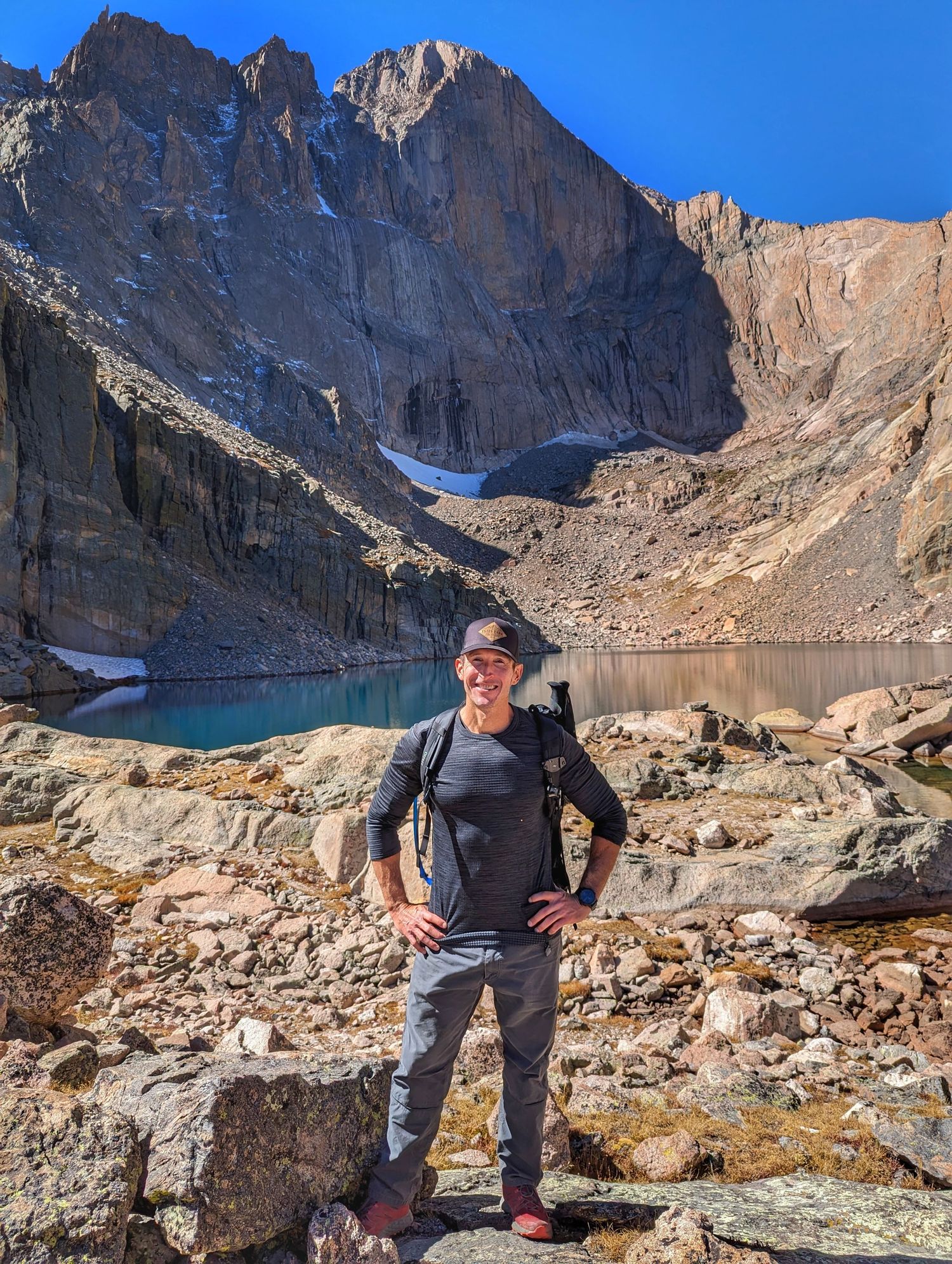 A photographer posing by a mountain lake.