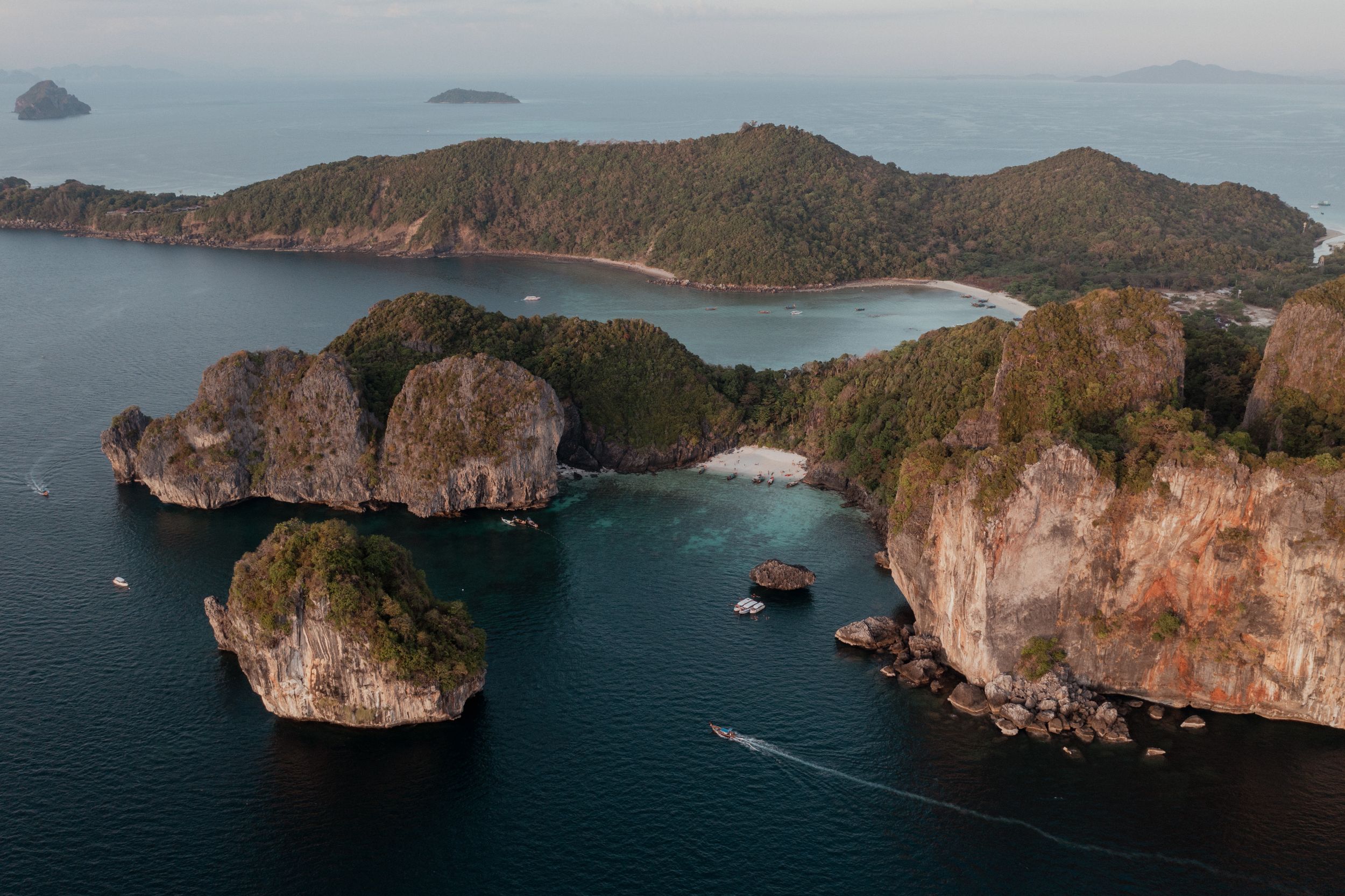 Aerial view of limestone islands and cliffs surrounded by deep blue ocean waters.