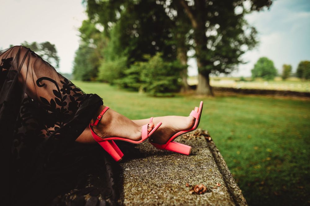 Artistic cemetery portrait showcasing black lace dress details against stone monuments.