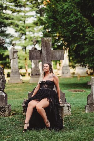 Gothic cemetery setting with old stone crosses and monuments on grass.