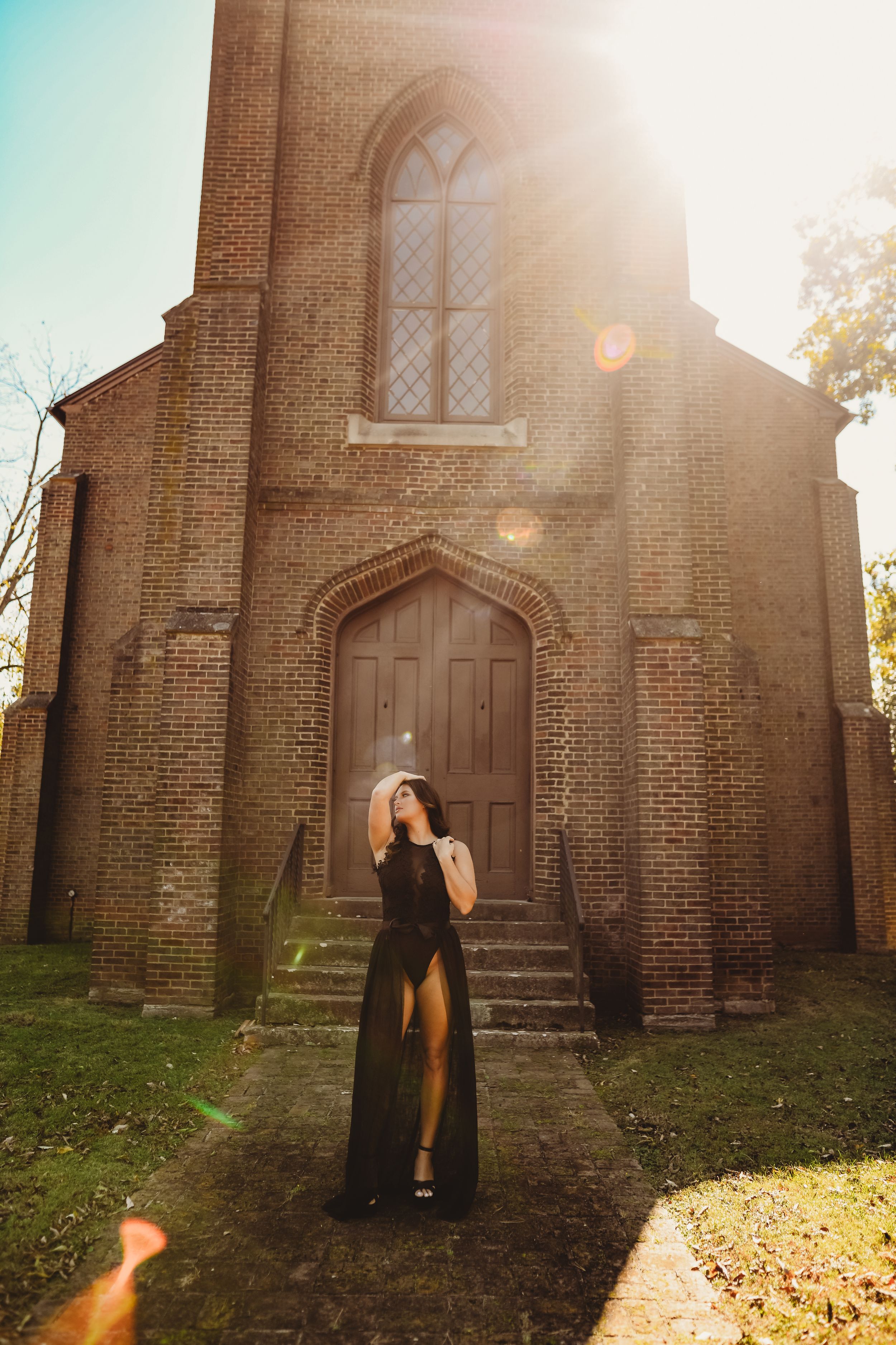 Sunlit gothic church facade creates dramatic backdrop for fashion portrait.