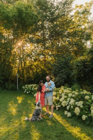 An outdoor family portrait with cat and dog