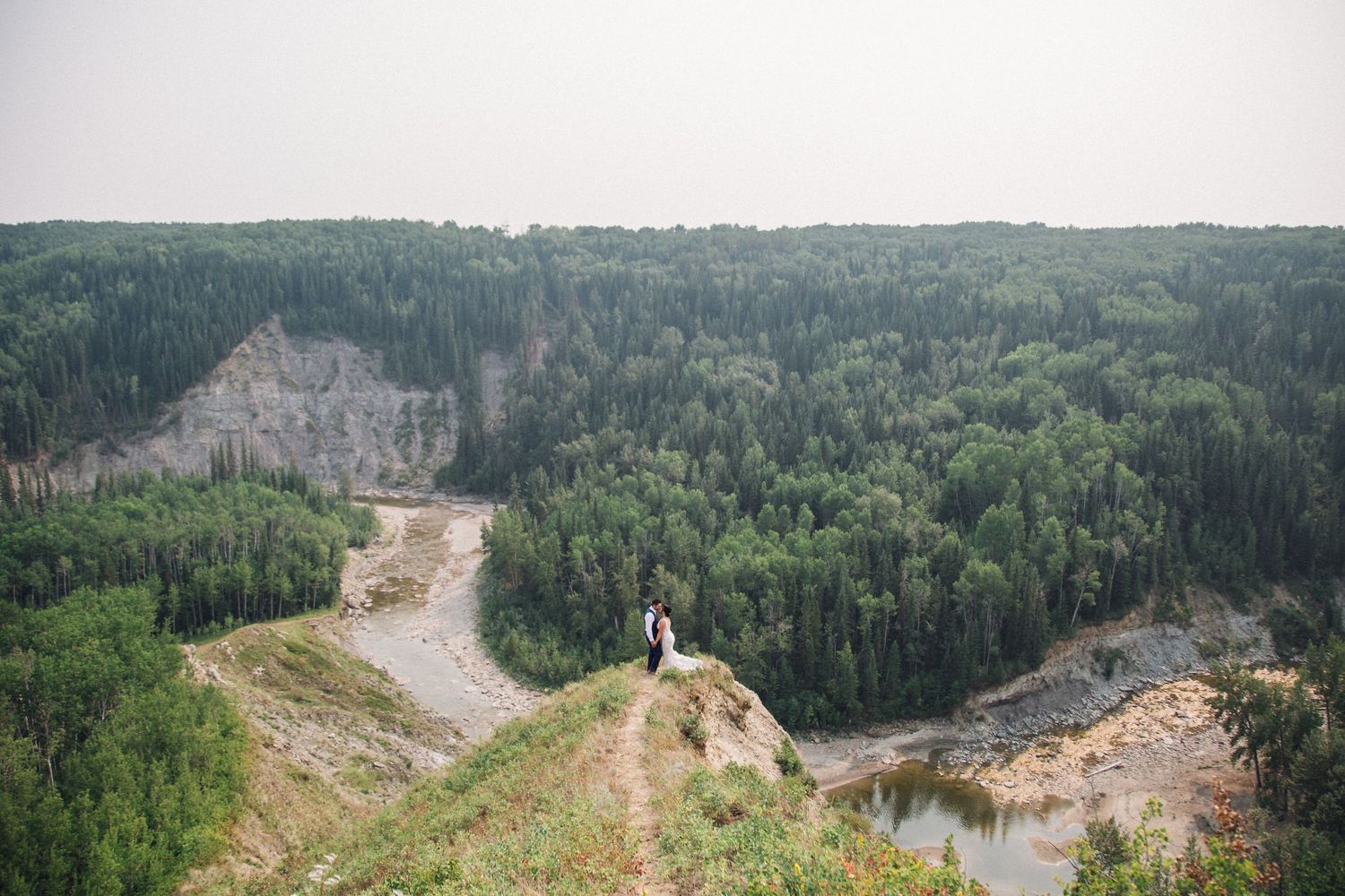 Dramatic cliff overlook with winding paths through a quarry landscape.