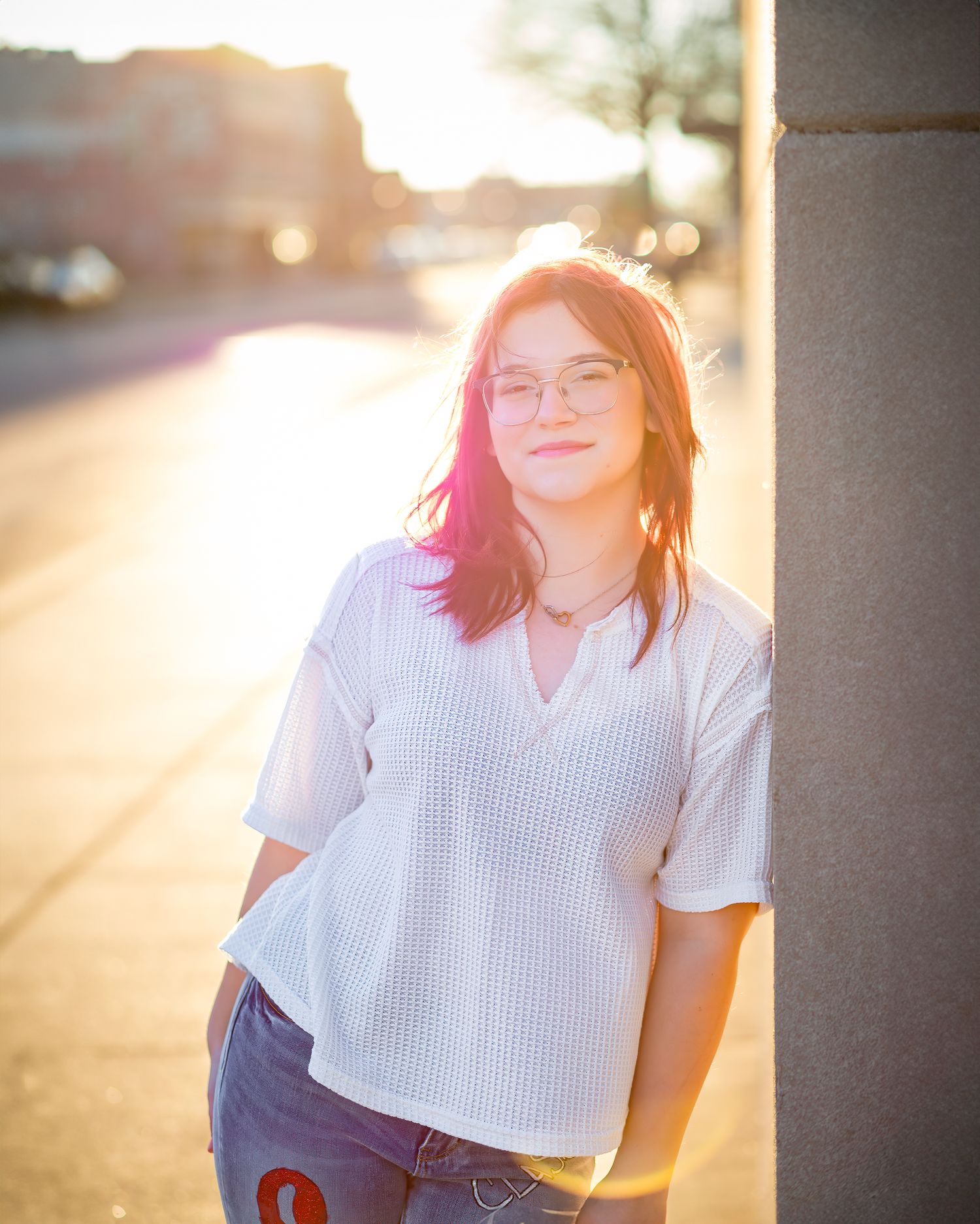 Warm sunset portrait against urban background with soft golden hour lighting.