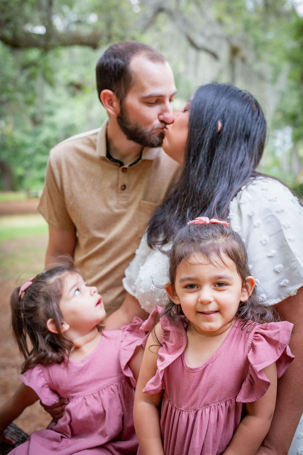 A series of candid outdoor family photos showing affectionate moments between parents and children in pink dresses.