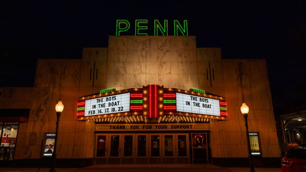 A classic theater with the marquee lit up