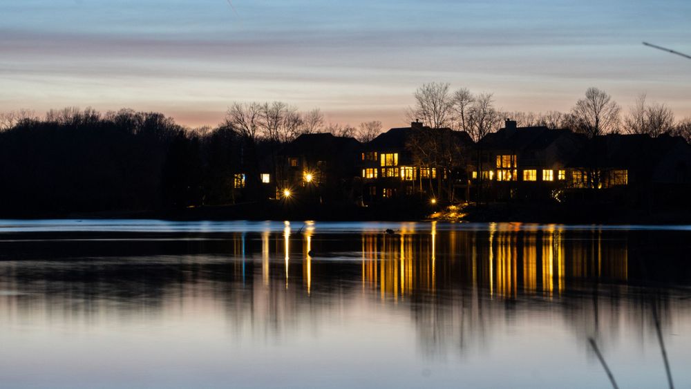 Houses across a lake with reflections in the water