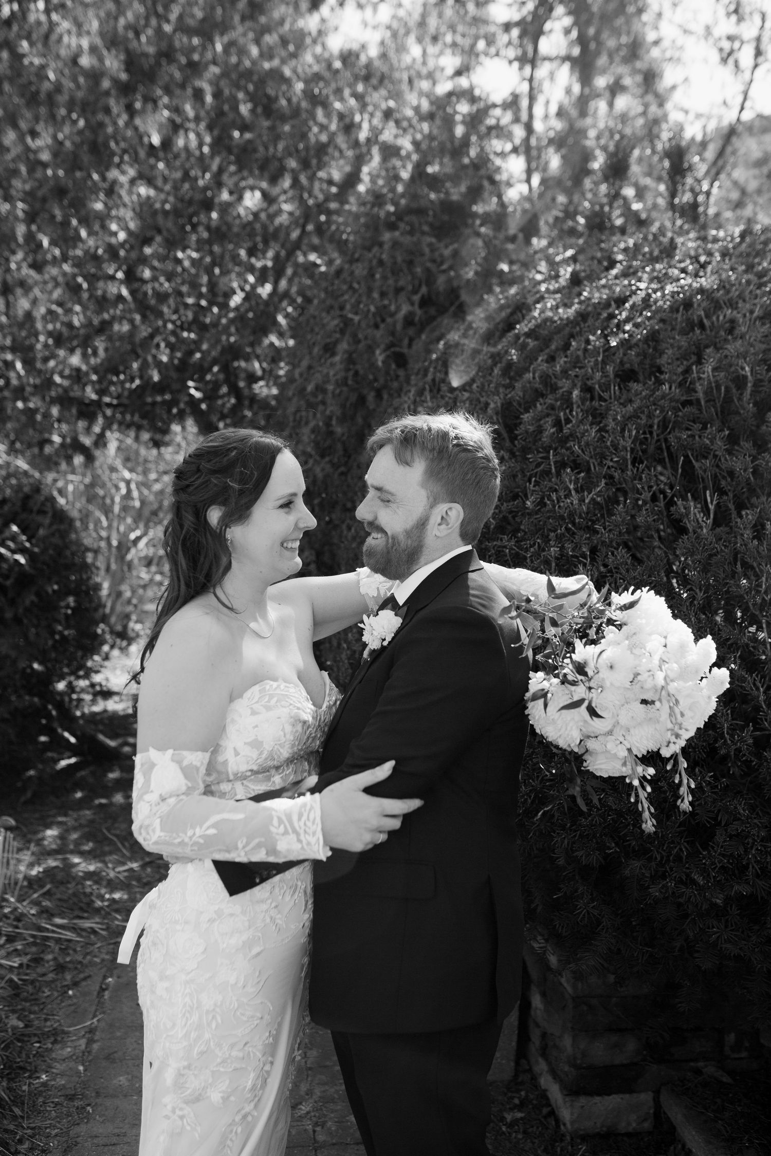 Wedding couple sharing intimate moments in a scenic meadow with trees.