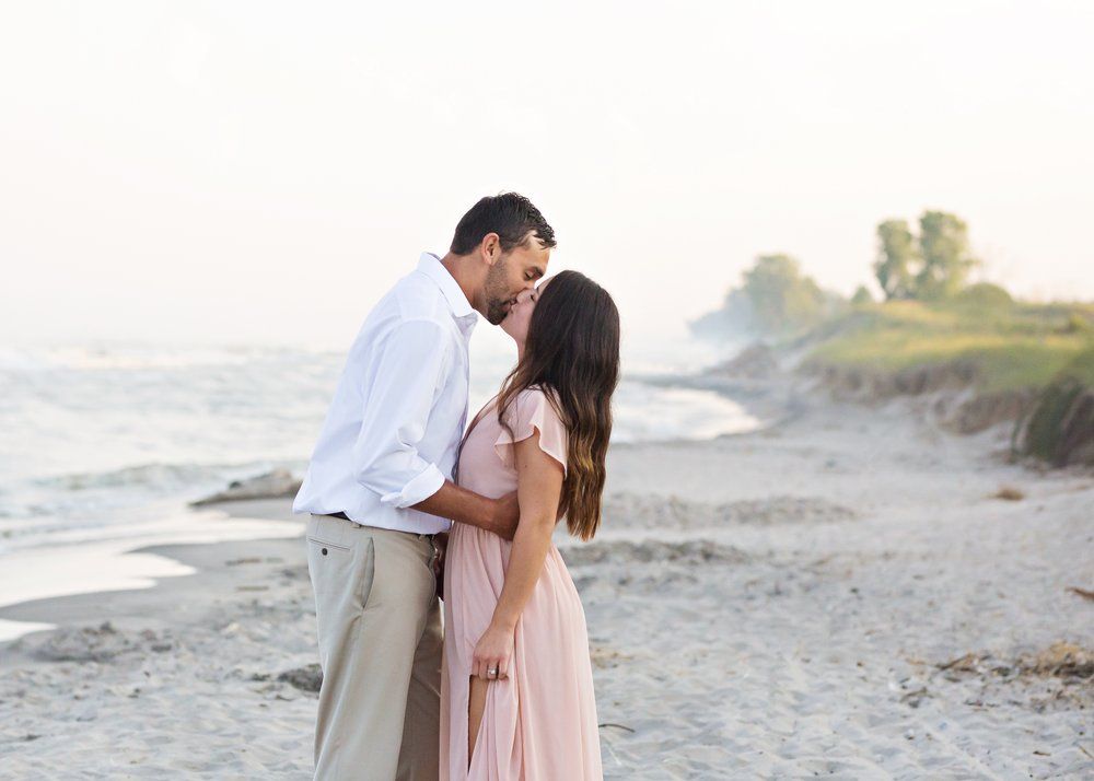 Engagement portrait of a couple in Kohler WI, showcasing natural smiles and love with a relaxed outdoor setting and soft, romantic light
