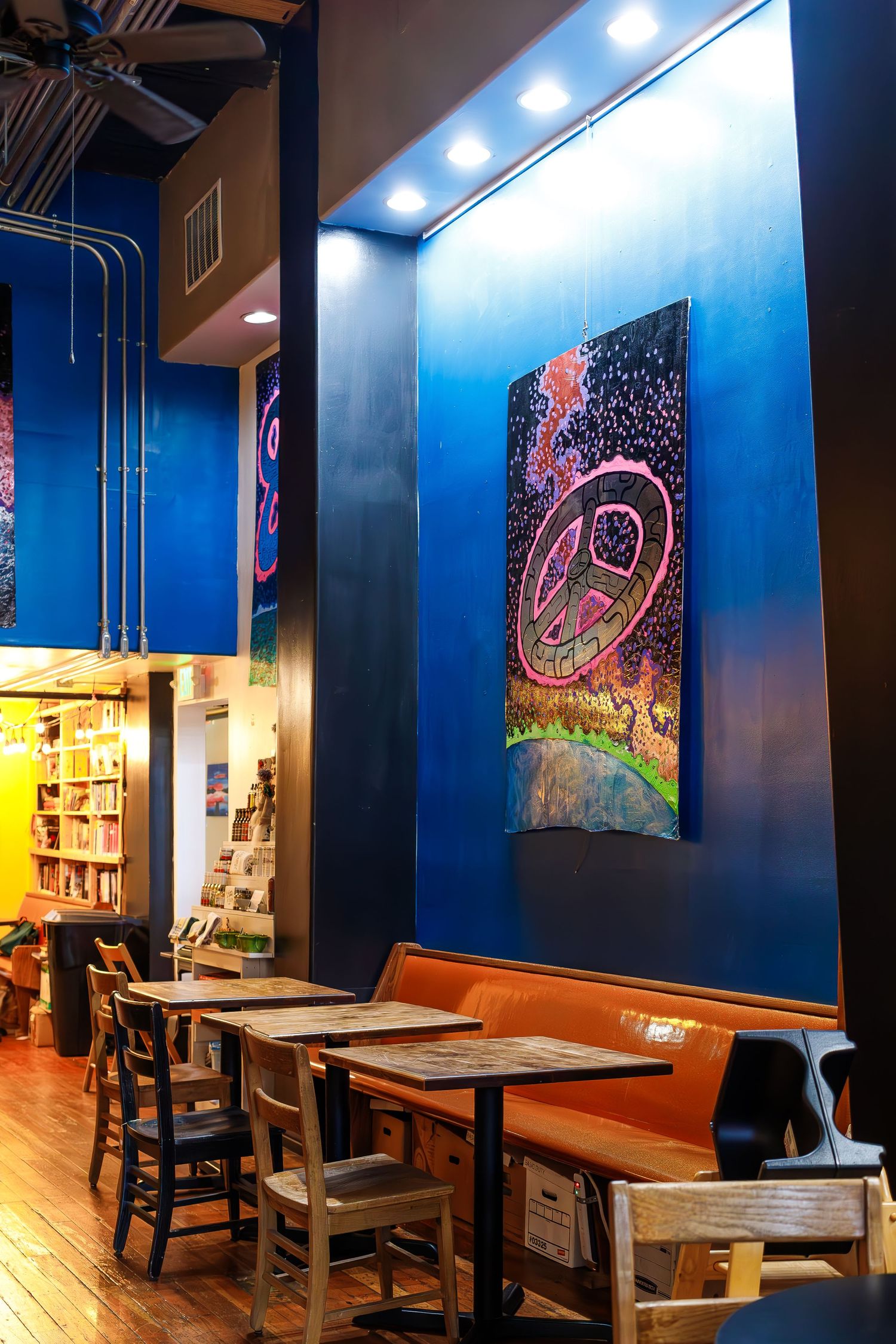 Cozy bookstore seating area with blue walls and artistic wall decor.