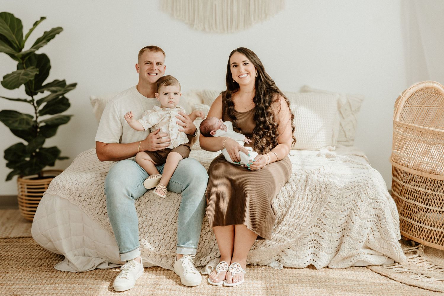 A casual family portrait in a bright boho-styled room with white decor.
