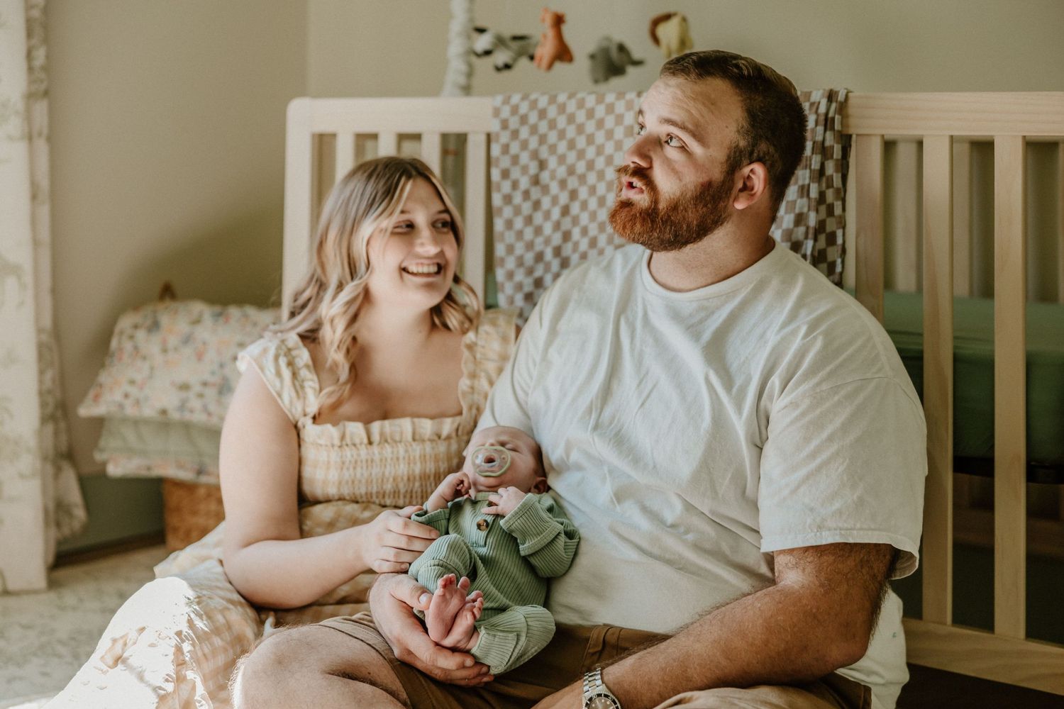 Sweet family moment captured in nursery with natural lighting.