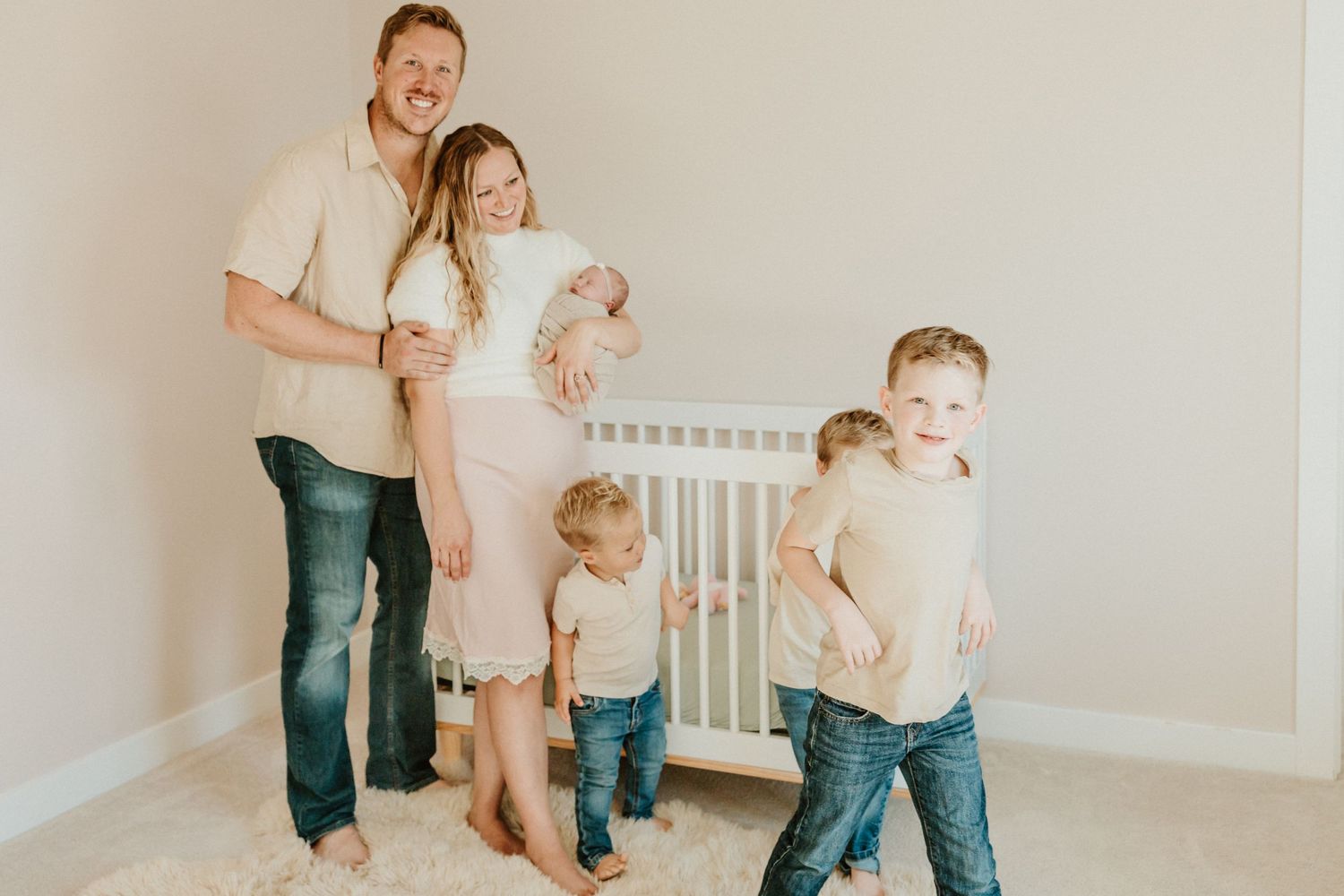 Candid family moment in nursery with casual neutral-toned clothing.