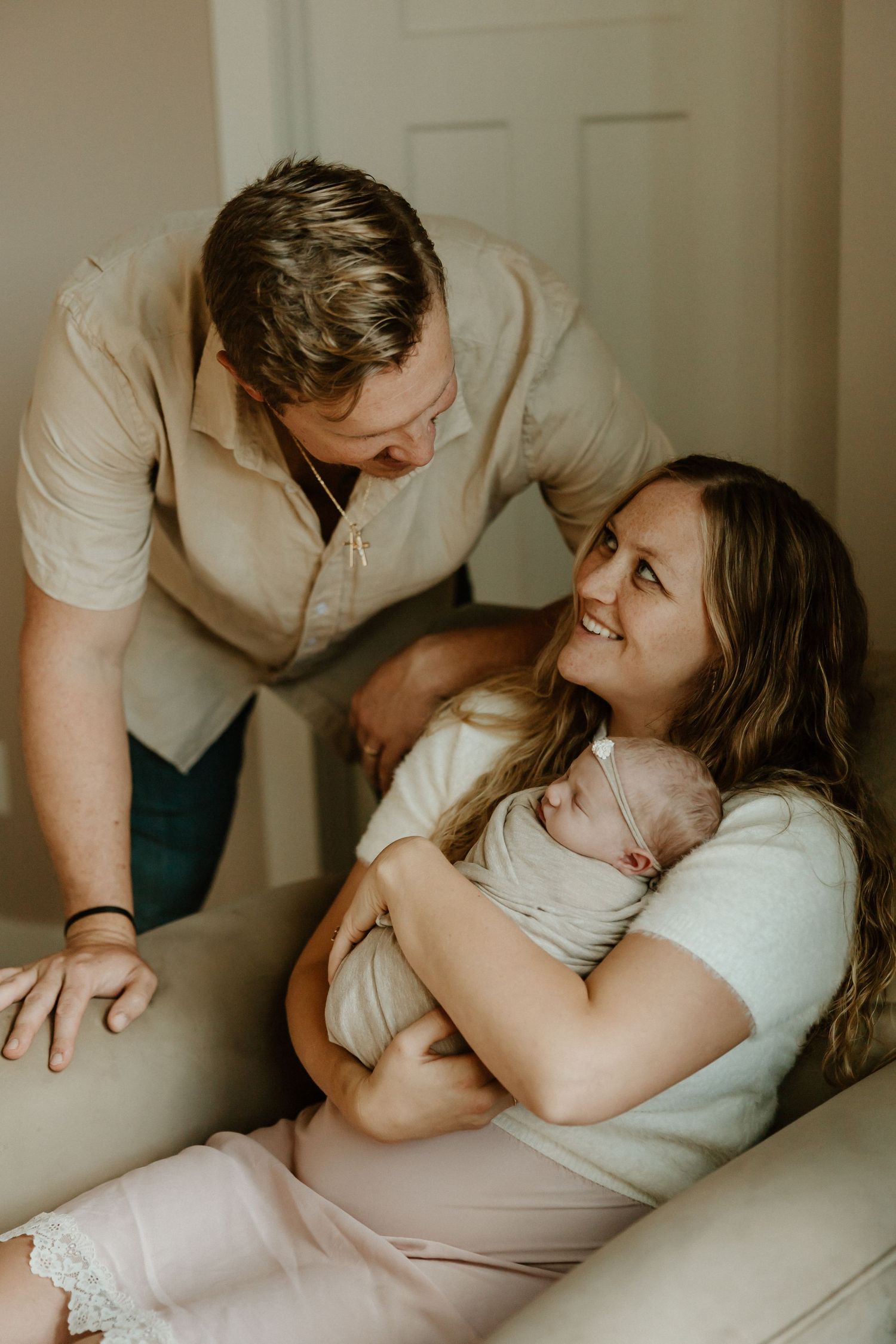 Intimate family moment with newborn in soft natural light.
