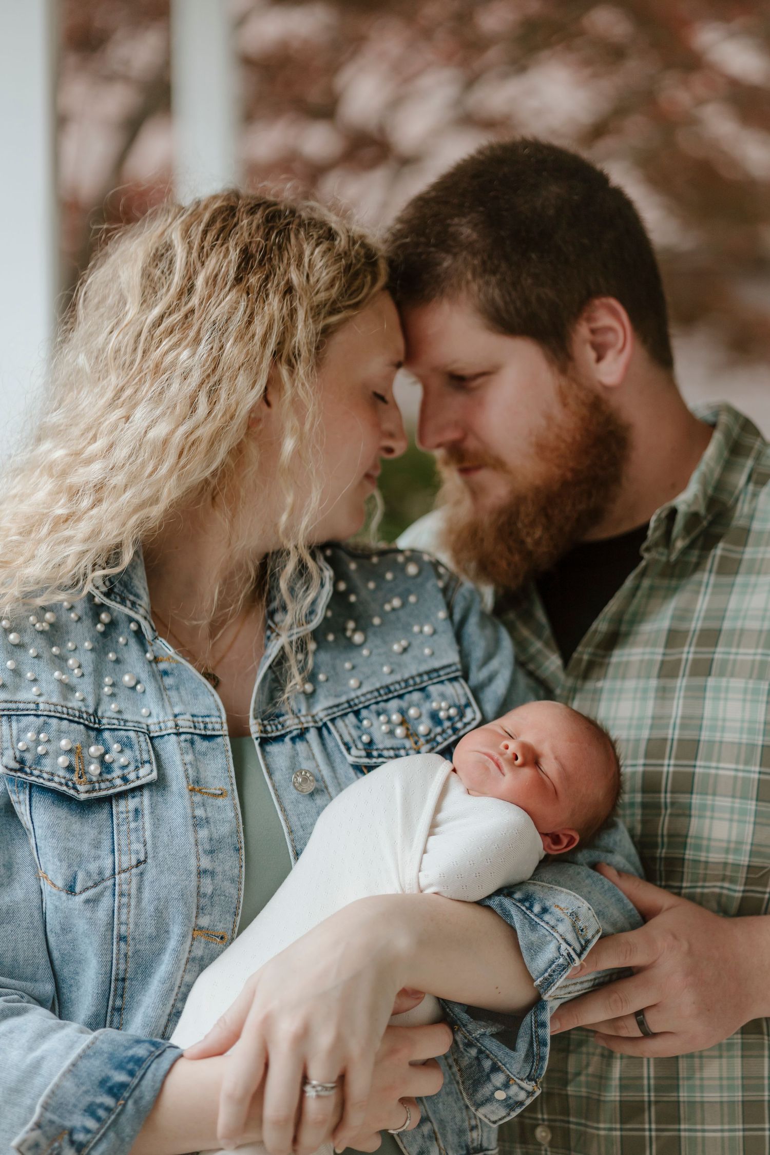 A tender family moment with a newborn baby captured outdoors in autumn colors.