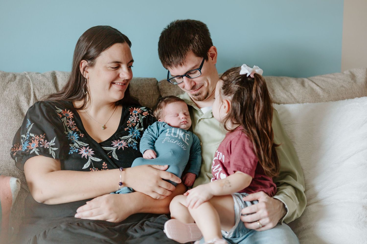 A loving family shares a joyful moment together on their living room couch.