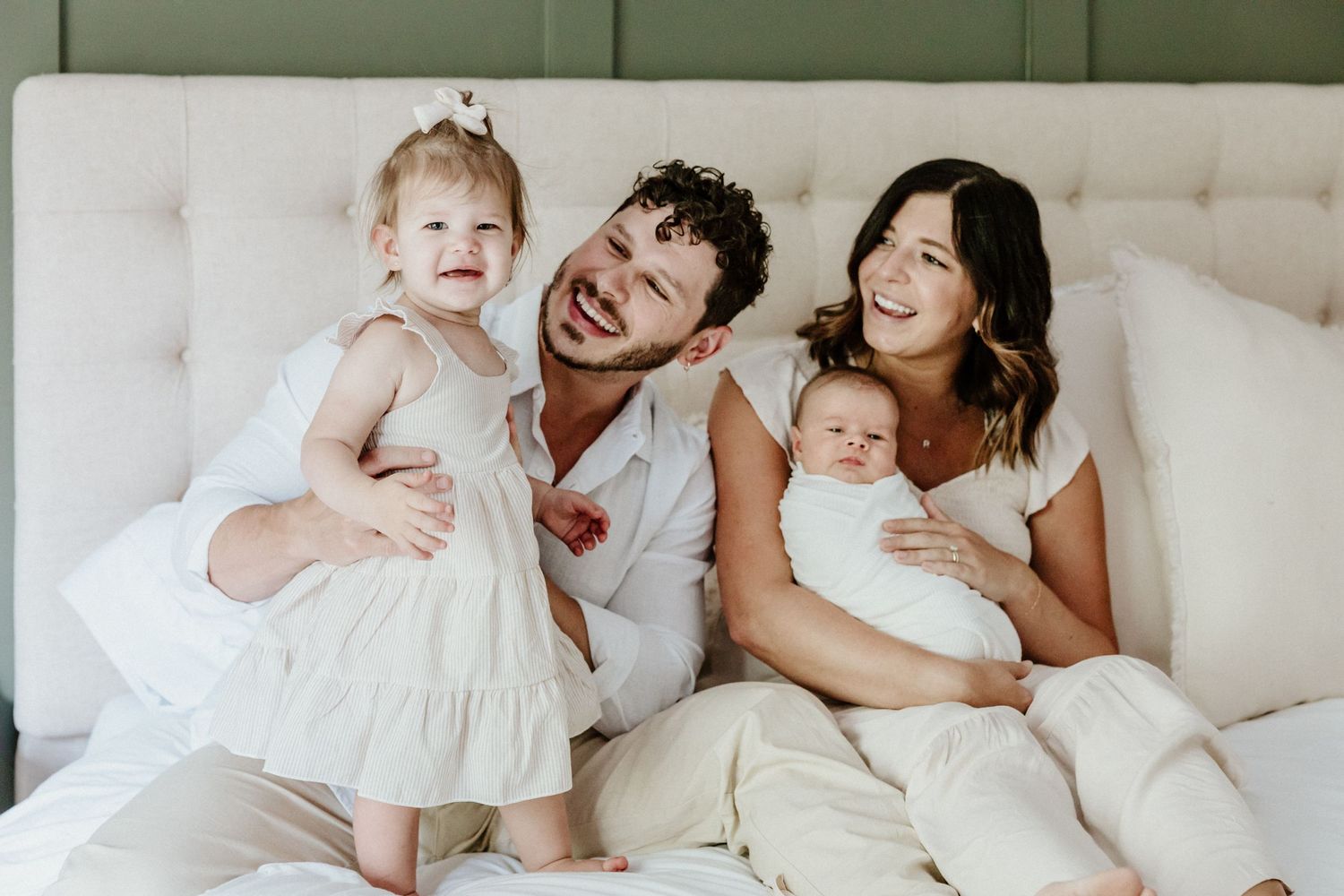 Happy family sharing joyful moment together on white couch.