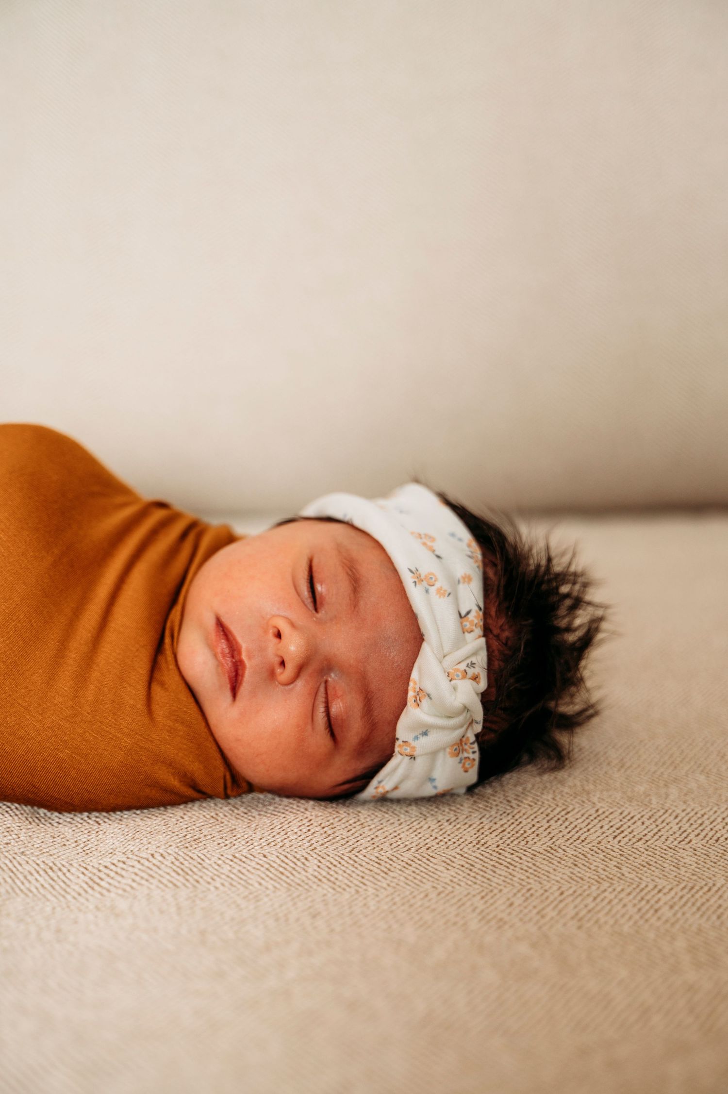 Brampton lifestyle newborn photographer captures baby sleeping while swaddled on couch