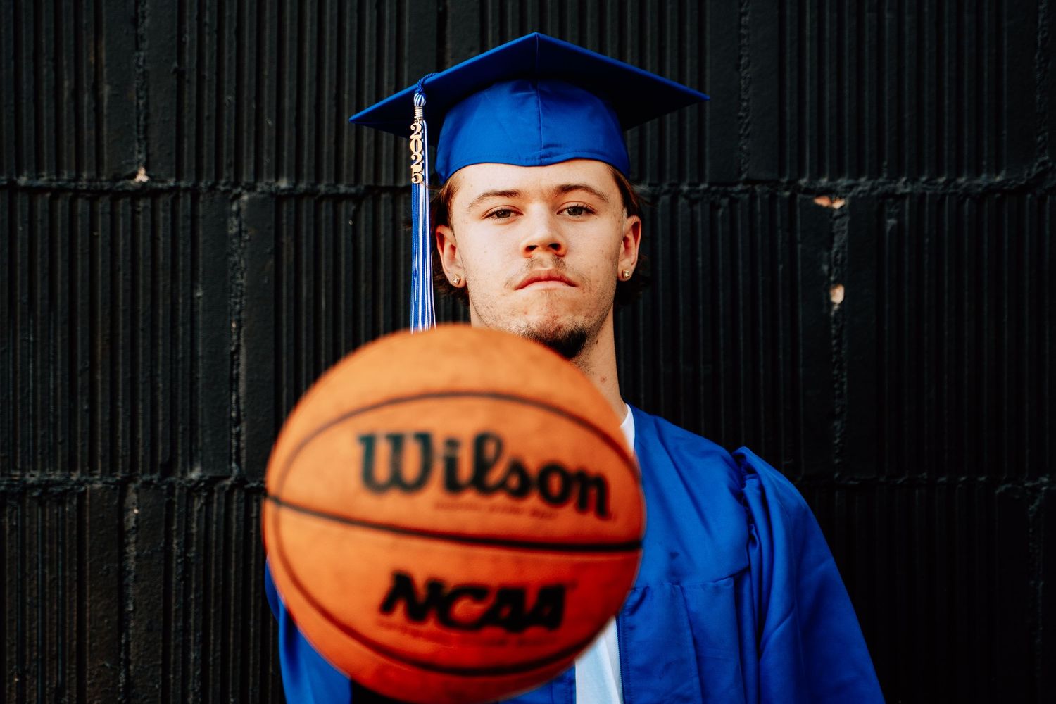 Basketball-themed senior photos with player holding ball against dark background.