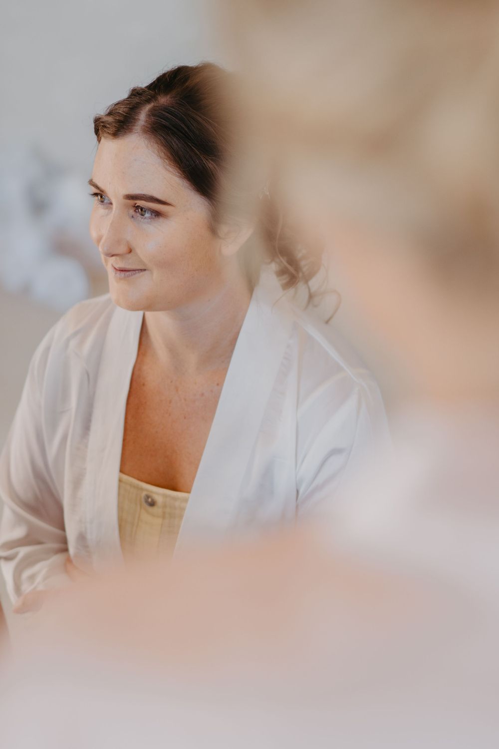 Soft portrait in natural light showing wedding day preparations.