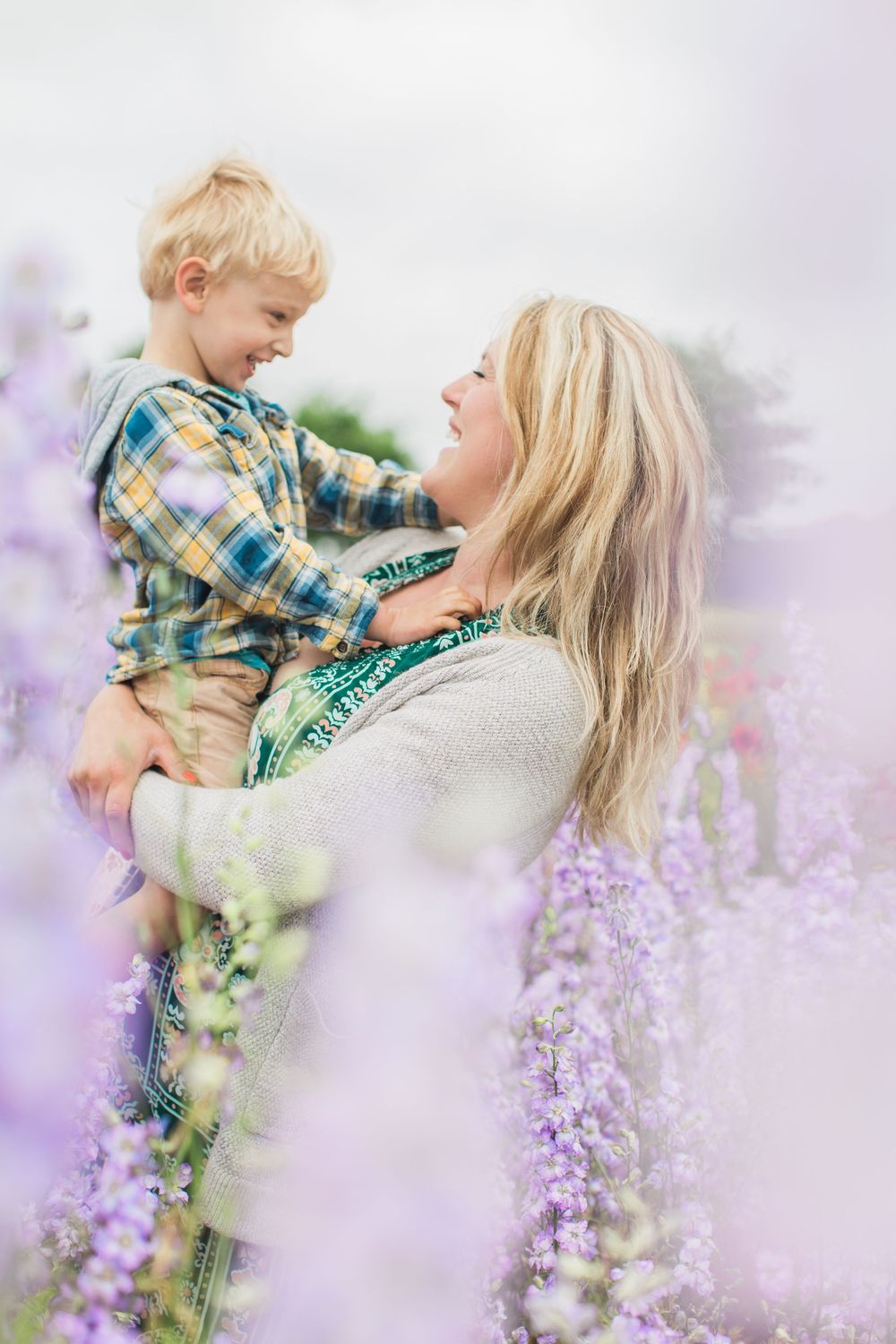 A tender moment shared between parent and child amid blooming lilac flowers in soft dreamy lighting by Hayley Elizabeth photography