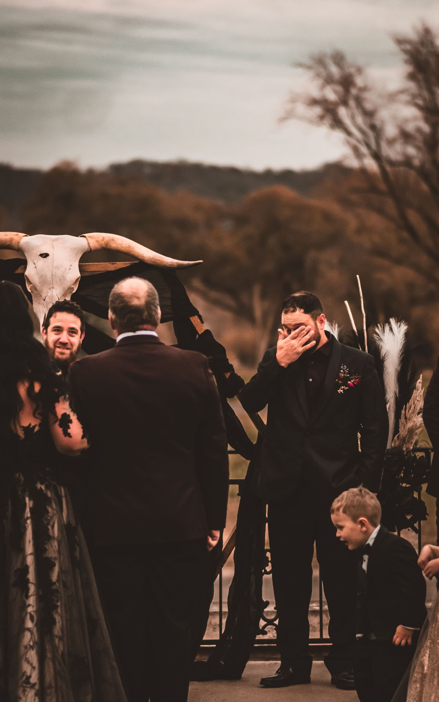 Emotional wedding ceremony moment with animal skull decor and rustic autumn backdrop.