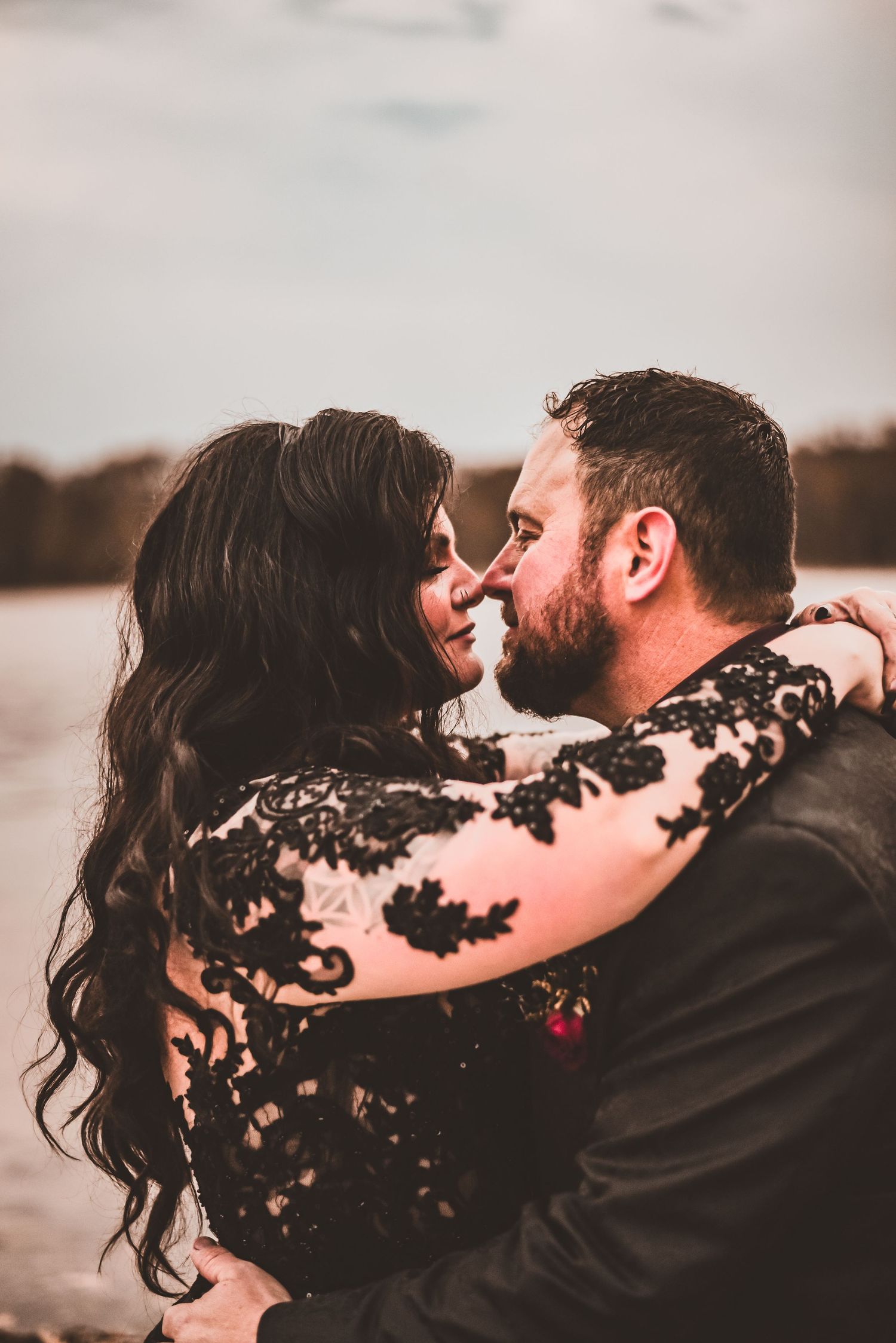 An intimate close-up of a couple in black lace and formal wear during their wedding photoshoot.