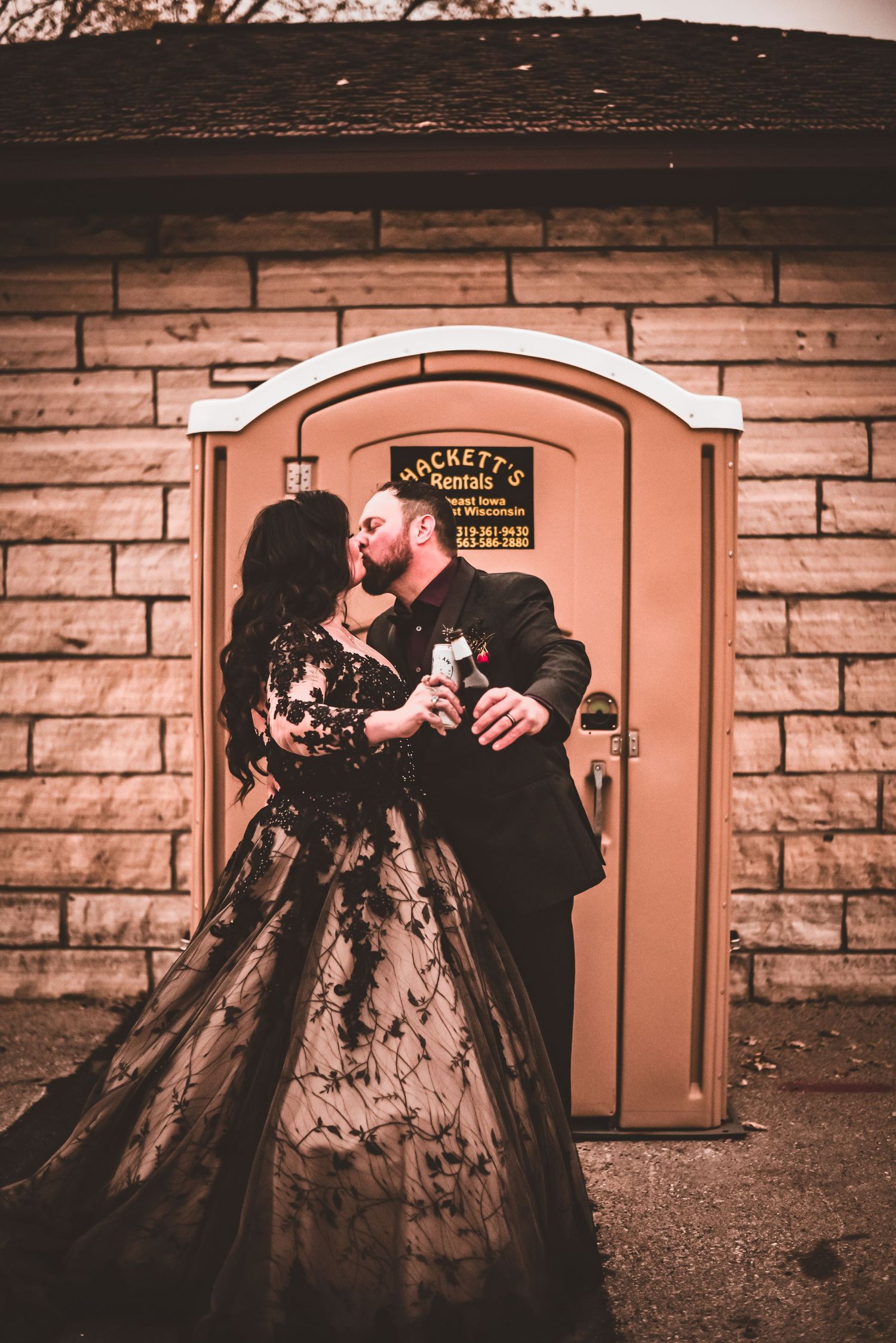A romantic moment captured in front of a vintage brick building with a peach-colored door.